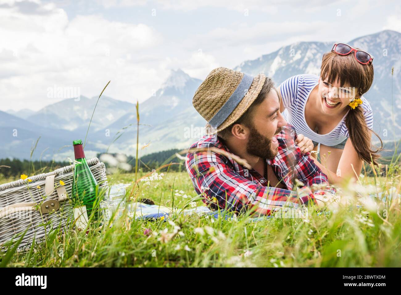 Couple heureux ayant un pique-nique sur un pré dans les montagnes, Achenkirch, Autriche Banque D'Images