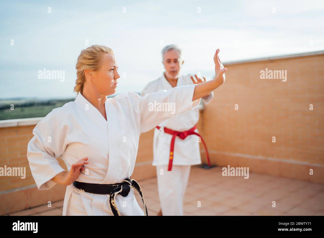 Femme avec professeur pendant la formation de karaté sur la terrasse Banque D'Images