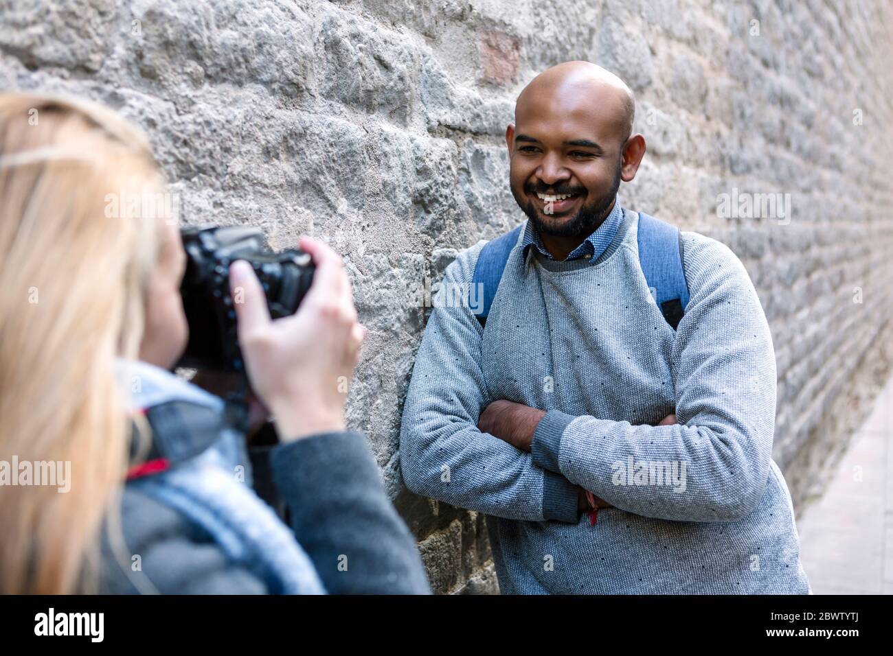 Femme prenant photo de son ami souriant avec appareil photo, Barcelone, Espagne Banque D'Images