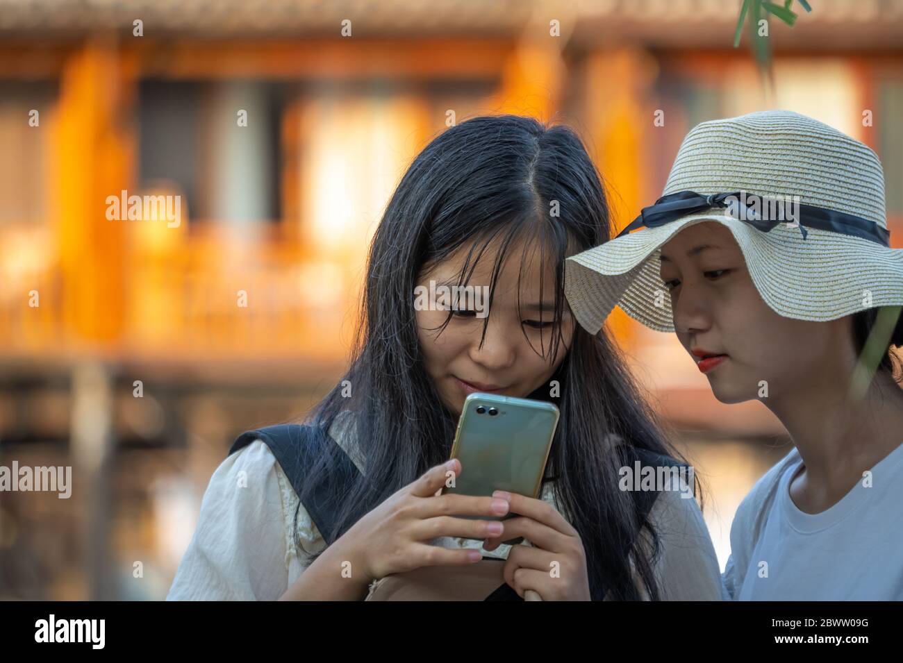 Feng Huang, Chine - août 2019 : adolescente chinoise et sa mère regardant le téléphone mobile, Feng huang Old Town Banque D'Images