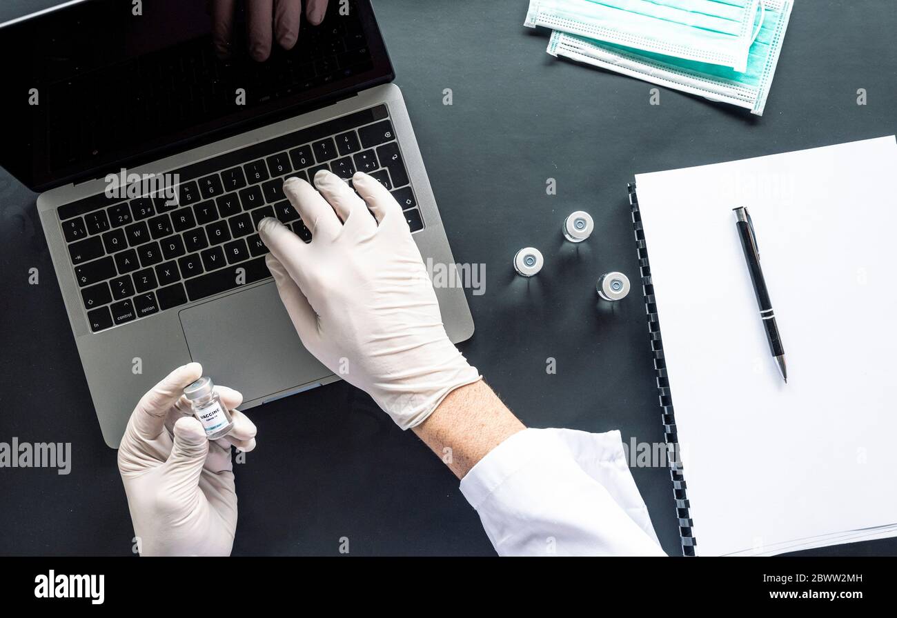 Directement au-dessus de la prise de vue d'un scientifique analysant un échantillon médical en utilisant un ordinateur portable au bureau dans le laboratoire Banque D'Images