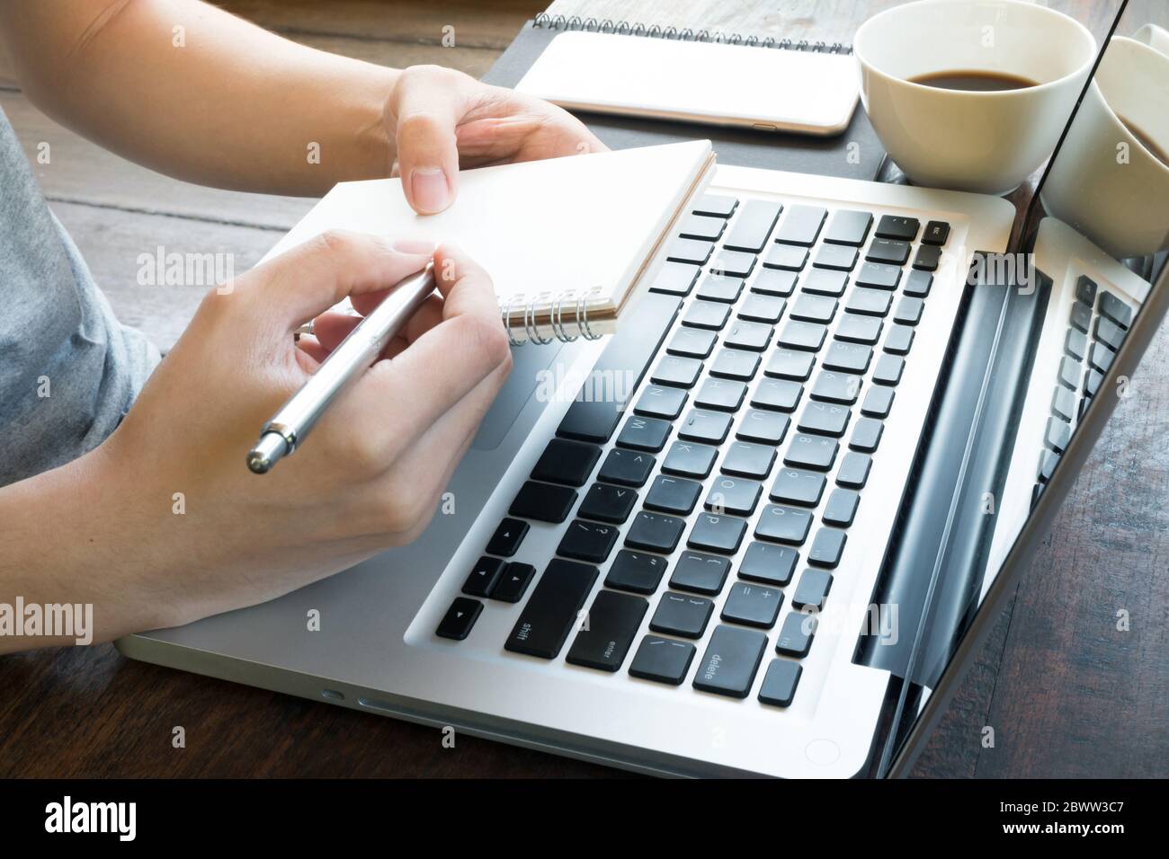 L'homme fait des recherches sur Internet et prend note. Application du filtrage des tons chauds. Banque D'Images