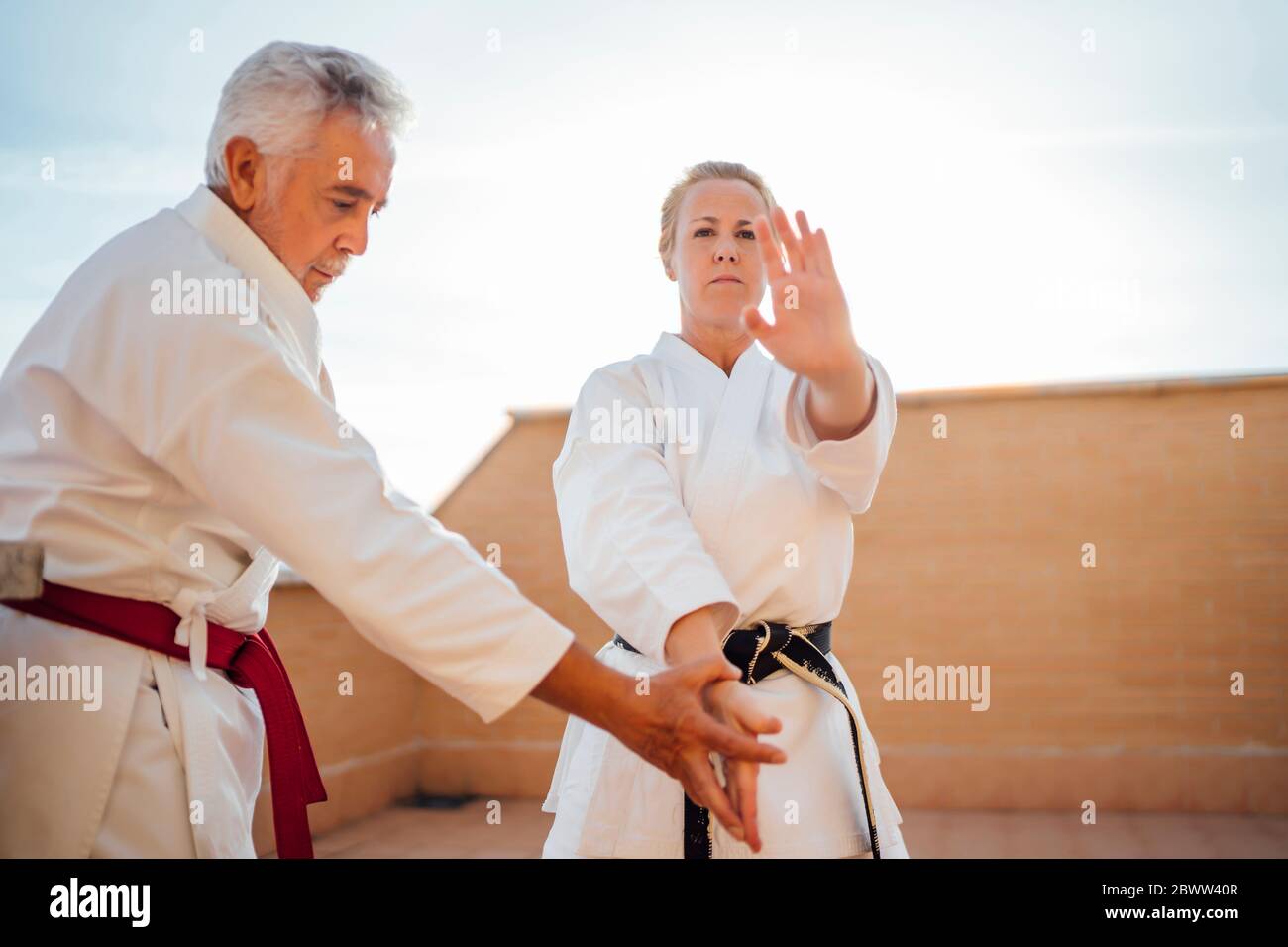 Femme avec professeur pendant la formation de karaté sur la terrasse Banque D'Images