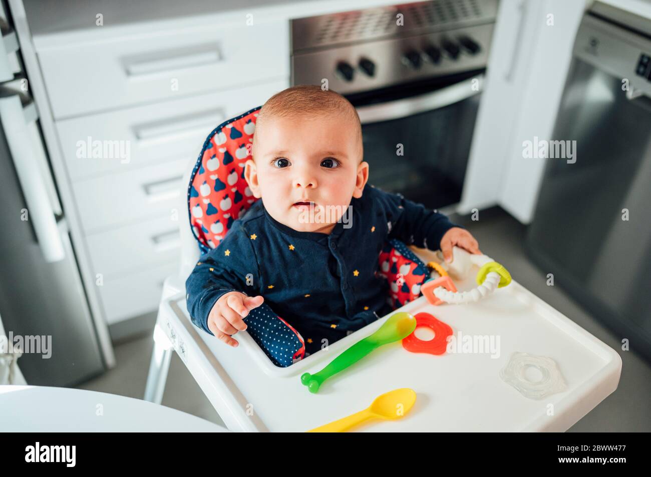 Portrait d'un bébé garçon en tête assis sur une chaise haute Banque D'Images