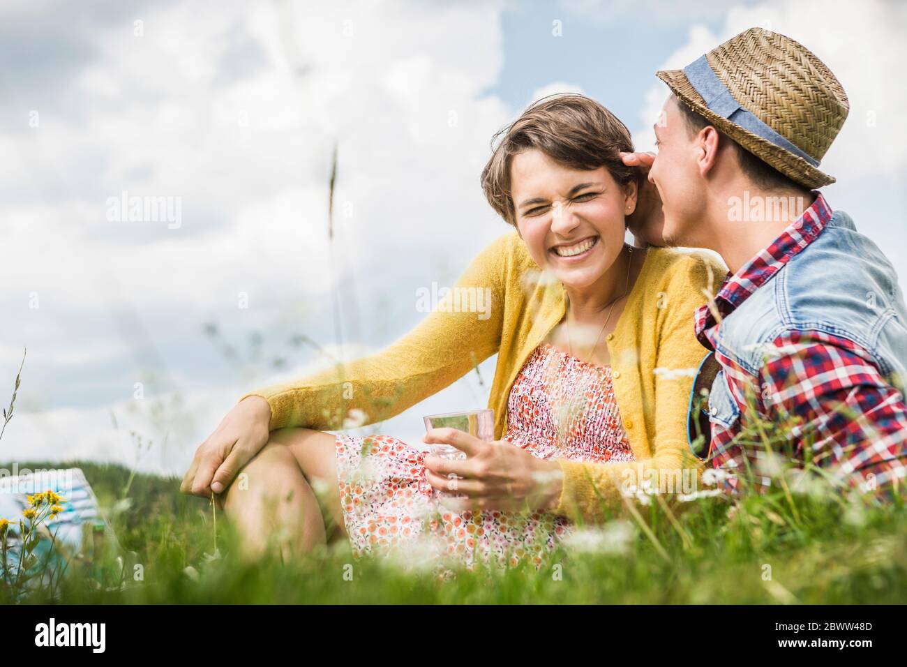 Couple heureux ayant un pique-nique sur un pré dans les montagnes, Achenkirch, Autriche Banque D'Images