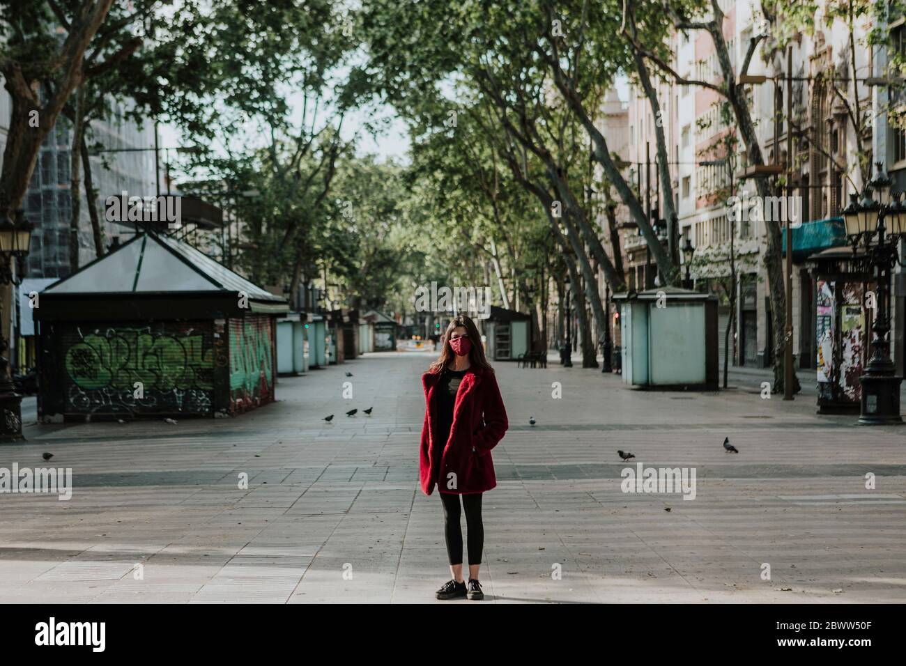 Portrait en longueur de la femme debout sur un sentier vide de la ville, Barcelone, Espagne Banque D'Images