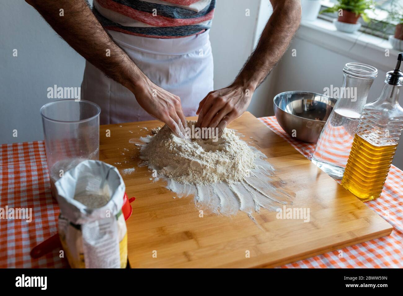 Vue rognée de l'homme en cuisine préparant la pâte Banque D'Images