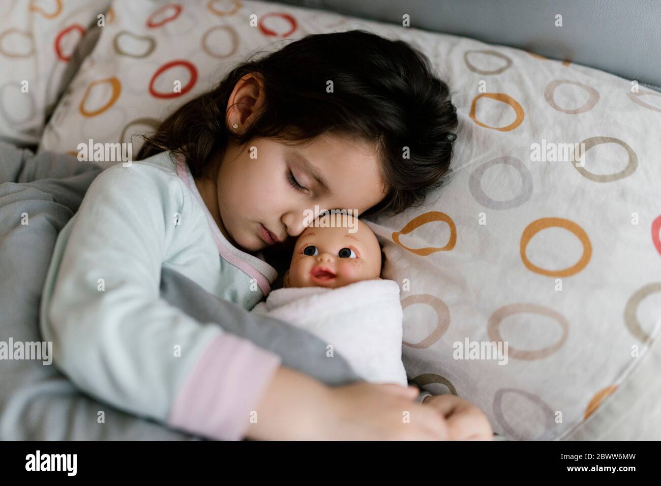 Petite fille endormi avec sa poupée Banque D'Images