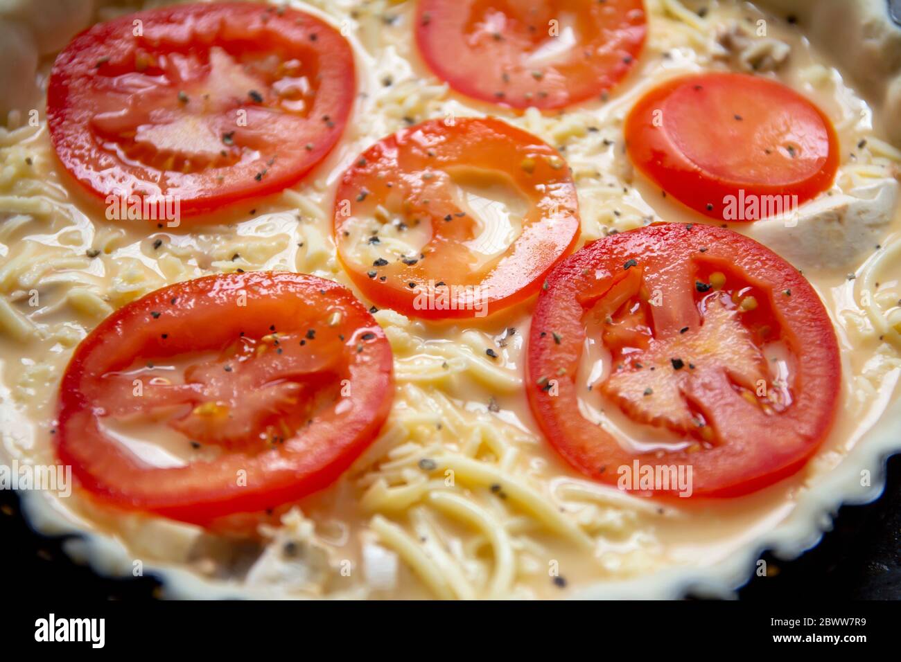 Le fromage non cuit et la tomate en forme de flan ont lu pour faire cuire Banque D'Images