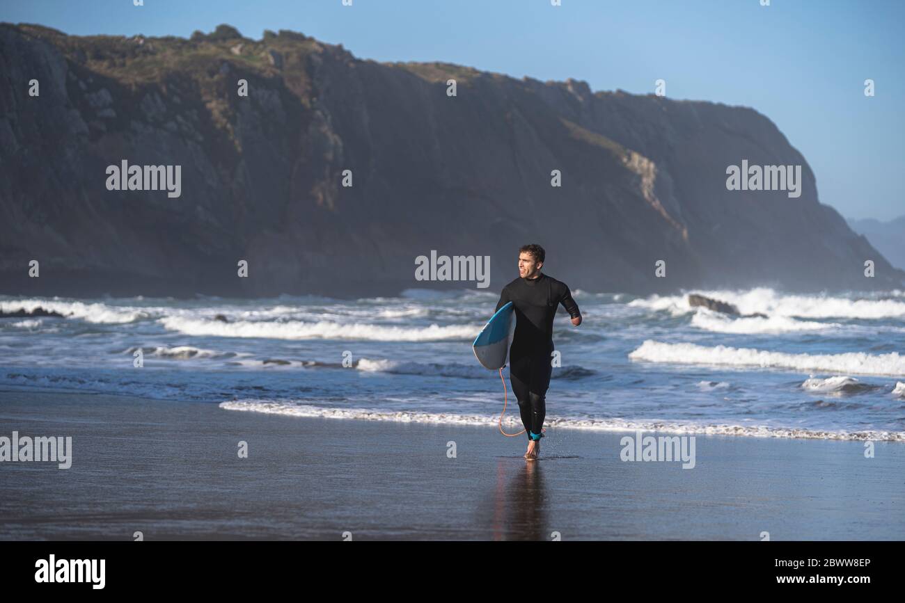 Surfeur handicapé avec planche de surf à la plage Banque D'Images