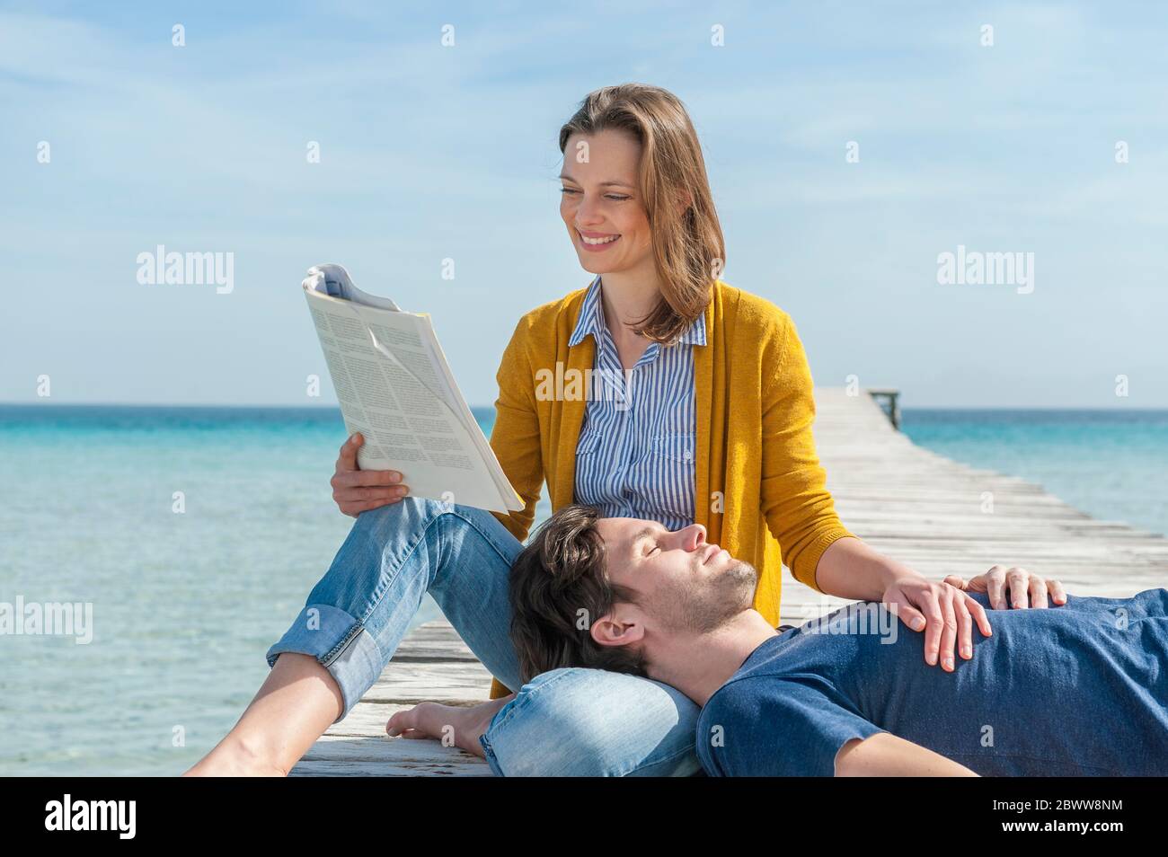 Portrait de la femme heureuse se relaxant avec son partenaire sur la jetée, Majorque, Espagne Banque D'Images