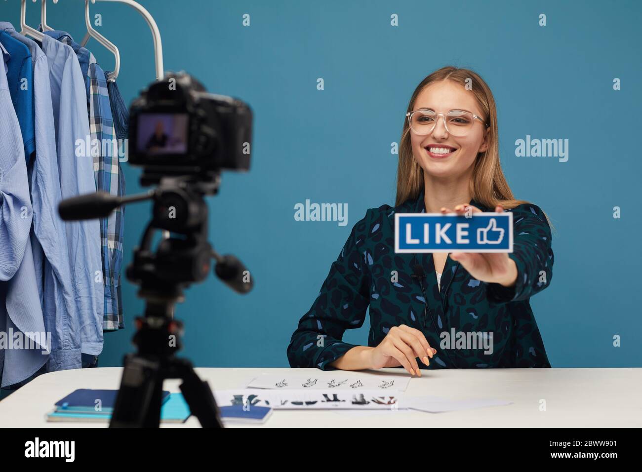 Jeune beauté blogueur demandant à aimer son contenu tout en parlant avec les gens en ligne Banque D'Images