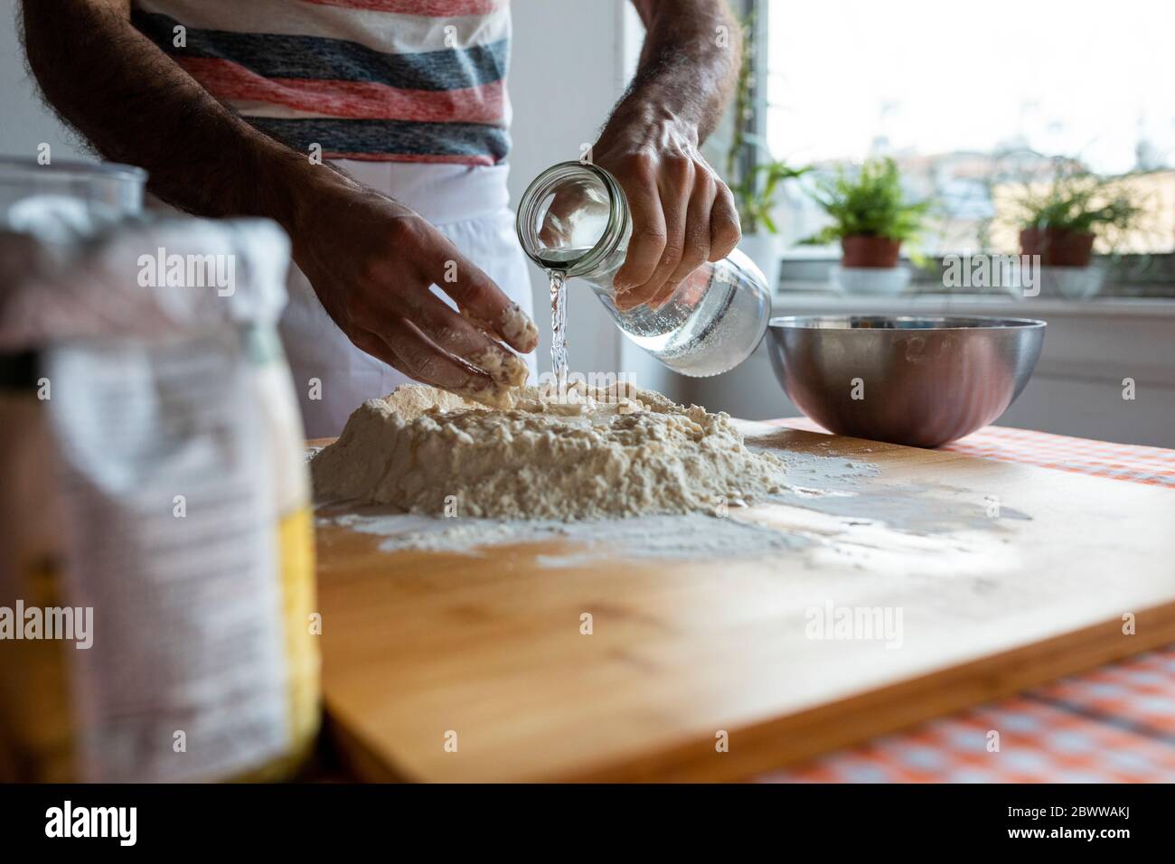 Vue rognée de l'homme en cuisine préparant la pâte Banque D'Images