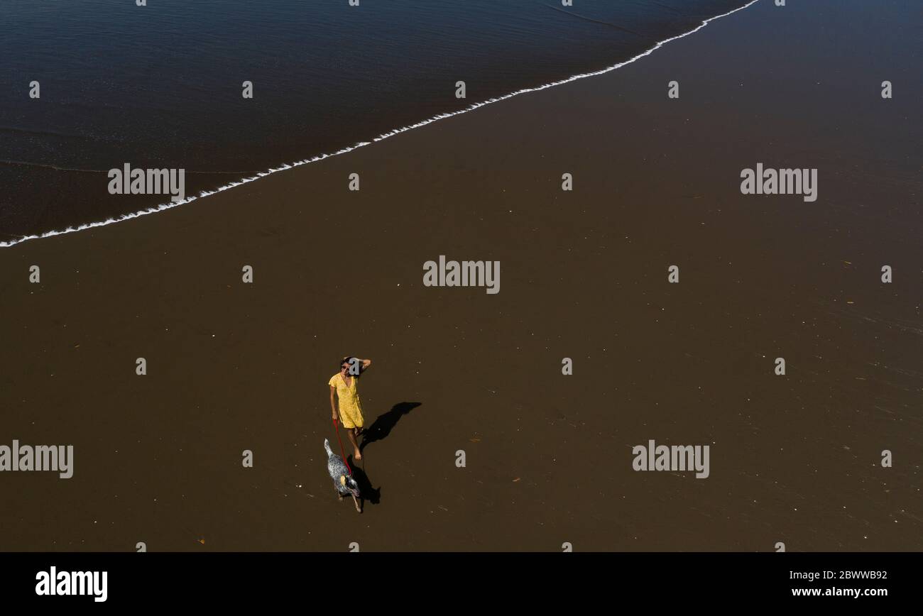 Jeune femme qui prend son chien pour une promenade à la plage, Costa Rica Banque D'Images