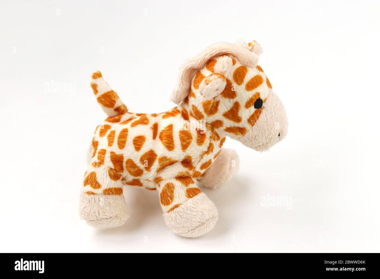Petite girafe pluschie isolée sur fond blanc avec réflexion d'ombre Banque D'Images