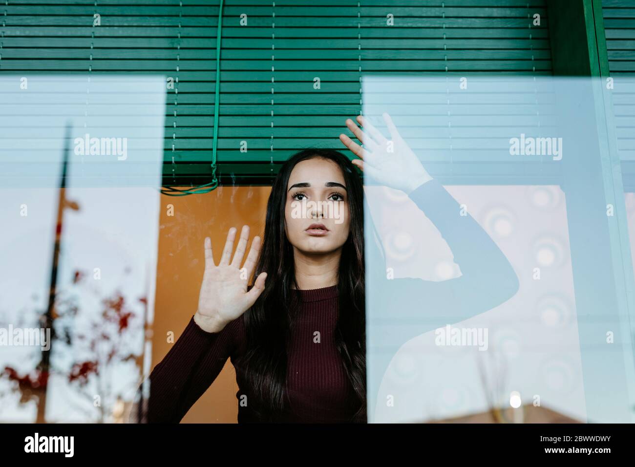 Portrait de jeune femme derrière la vitre Banque D'Images