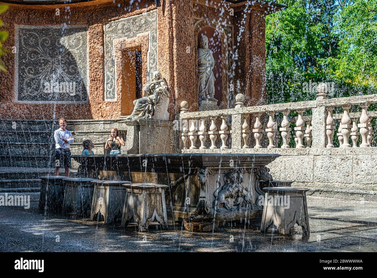 Des fontaines à l'ombre d'une table à dîner et des sculptures sur l'étang dans les jardins publics du palais Hellbrunn (Schloss Hellbrunn) de Salzbourg Banque D'Images