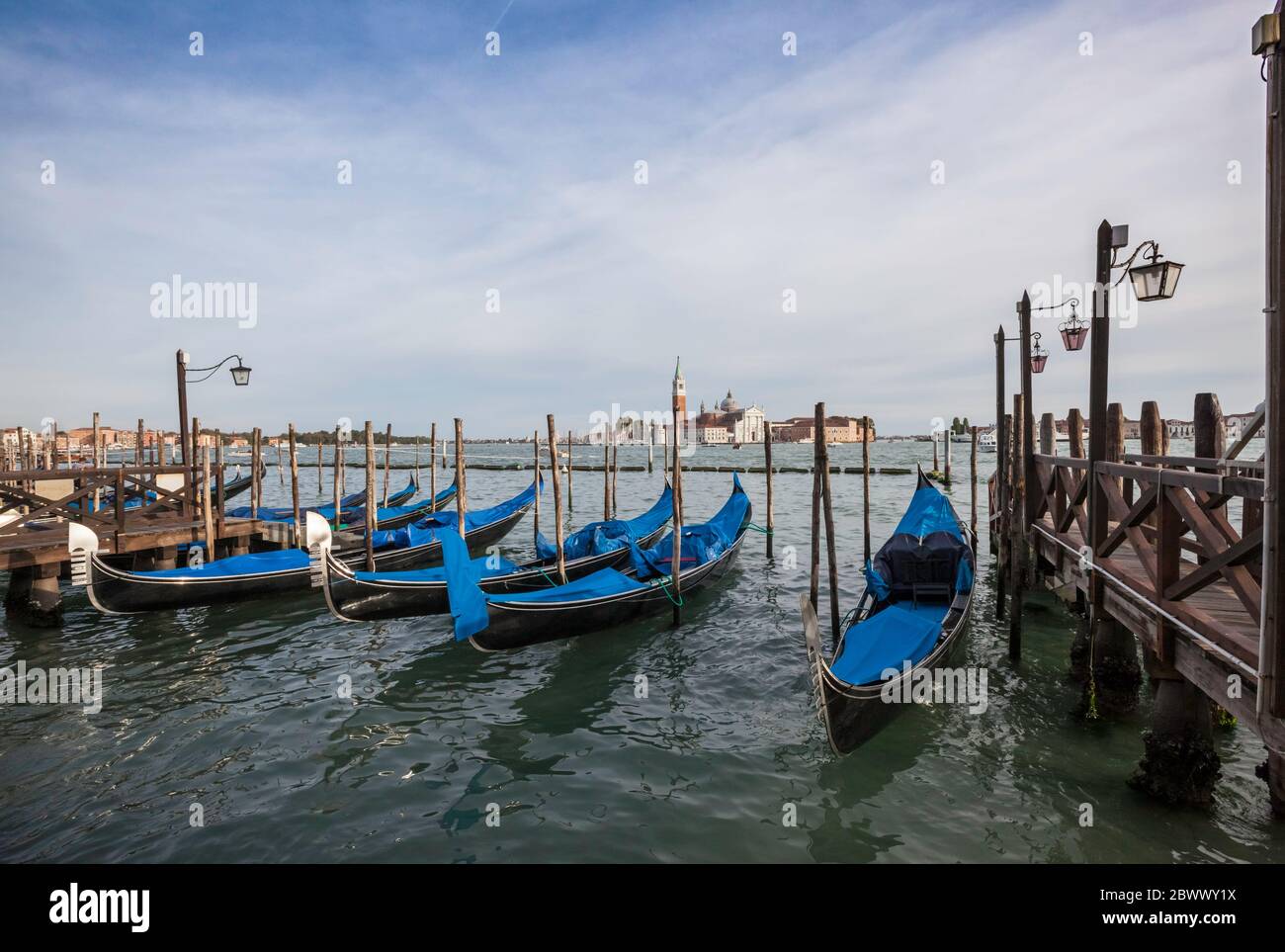 Gondoles amarrées le long de la Riva degli Schiavoni à Venise, en Italie, avec la Chiesa San Giorgio Maggiore en arrière-plan Banque D'Images