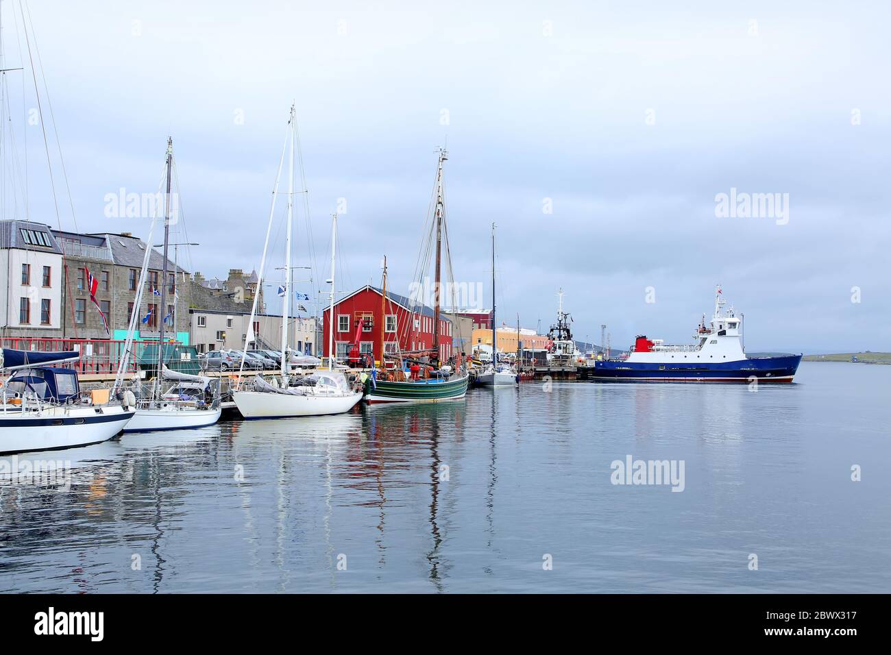 Port avec bateaux de pêche, bateau de sauvetage et bâtiments en arrière-plan, Lerwick, Shetland Islands, Écosse. Banque D'Images