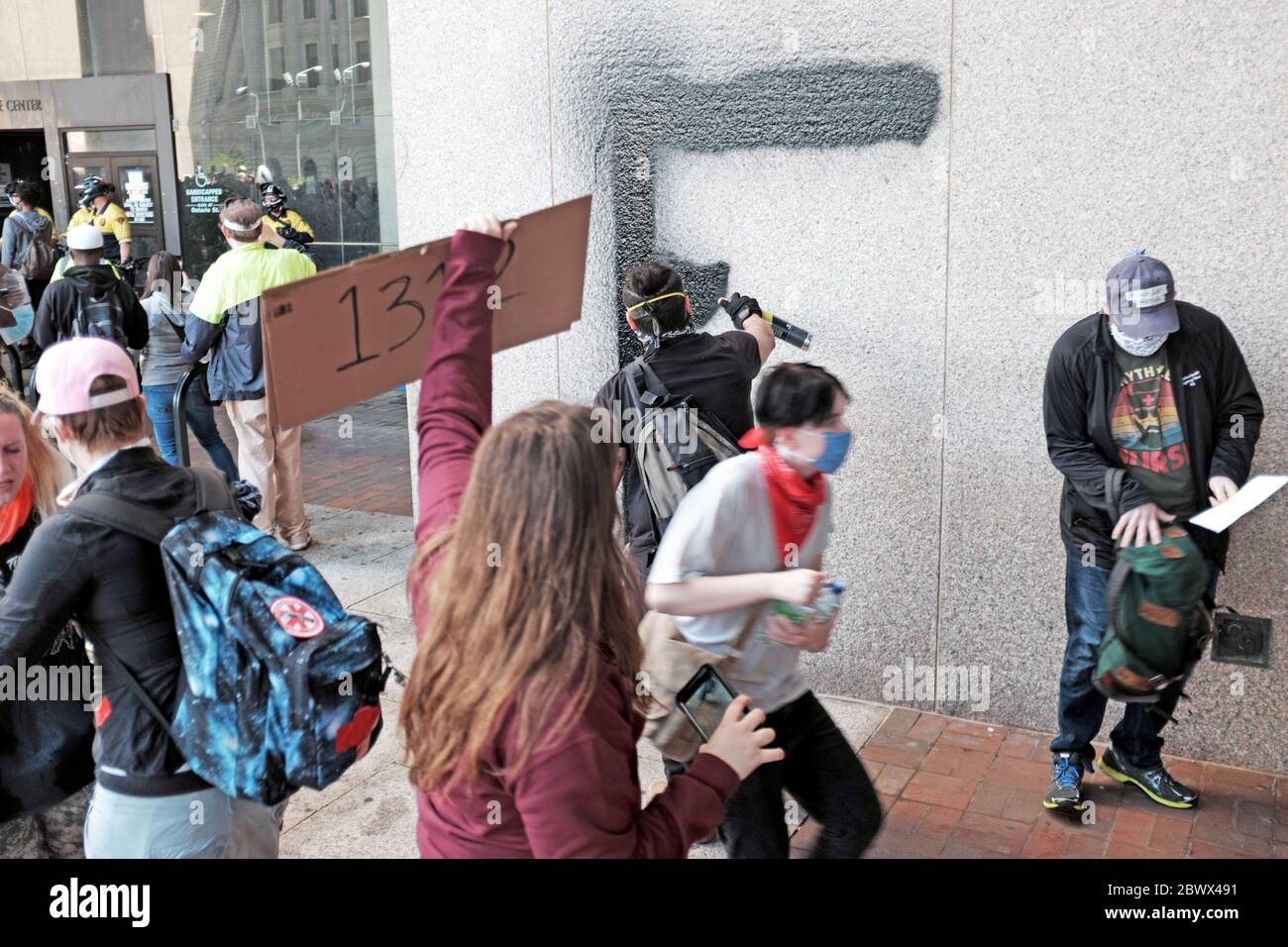 Un désordre s'ensuivra à l'entrée du Cleveland Justice Center à Cleveland, Ohio, États-Unis, alors qu'un manifestant marque le bâtiment. Banque D'Images