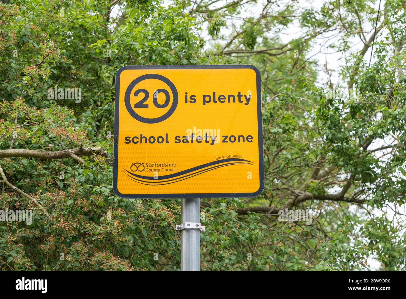 Panneau jaune vif indiquant « 20 is Plenty » zone de sécurité scolaire dans le village de Fradley, dans le Staffordshire, près de Lichfield Banque D'Images