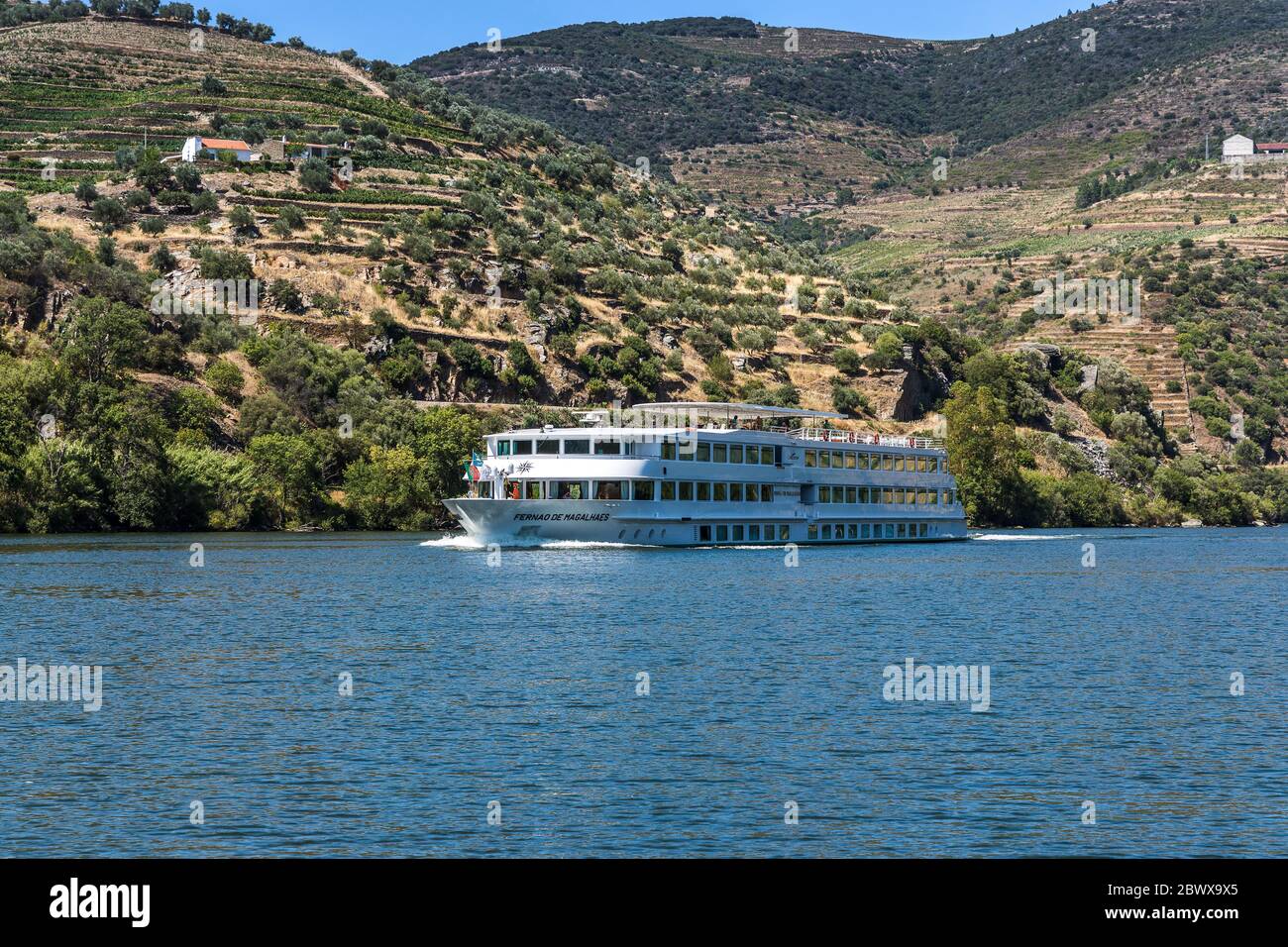 Bateau de croisière fluvial Fernao de Magalhaes sur la rivière avec les vignobles en terrasse de la vallée du Douro au nord du Portugal Banque D'Images