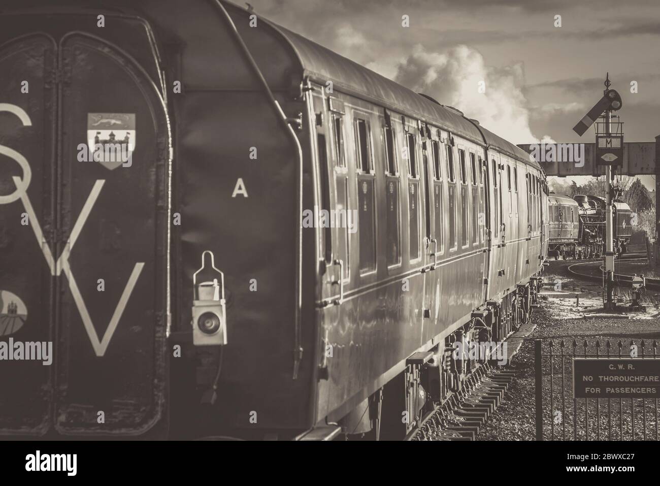 Vue arrière monochrome du train à vapeur britannique d'époque en quittant la gare de Kidderminster, ligne du patrimoine Severn Valley Railway. Trains vintage UK. Banque D'Images