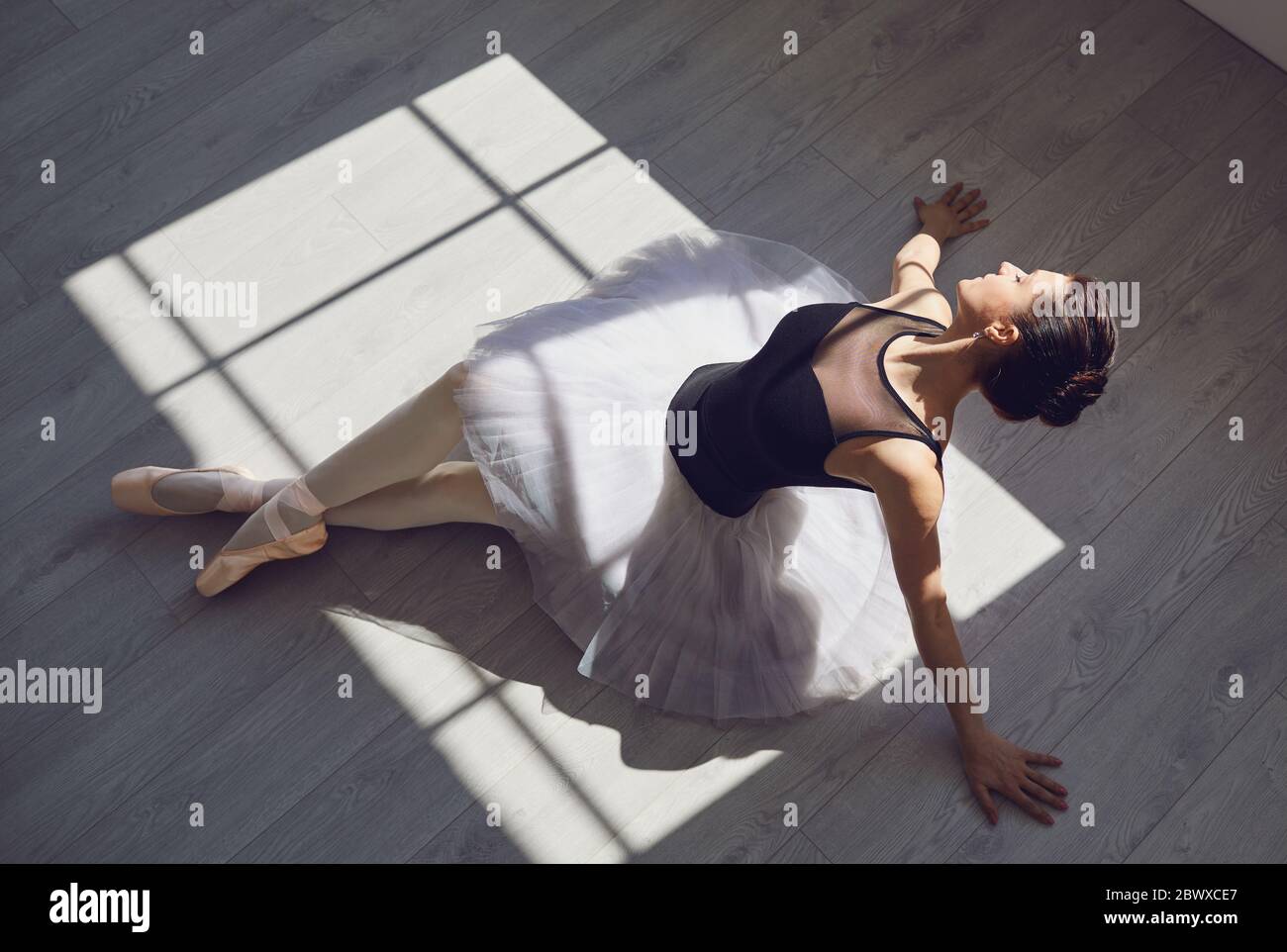 Ballerina à l'étage dans un studio avec fenêtres. Banque D'Images