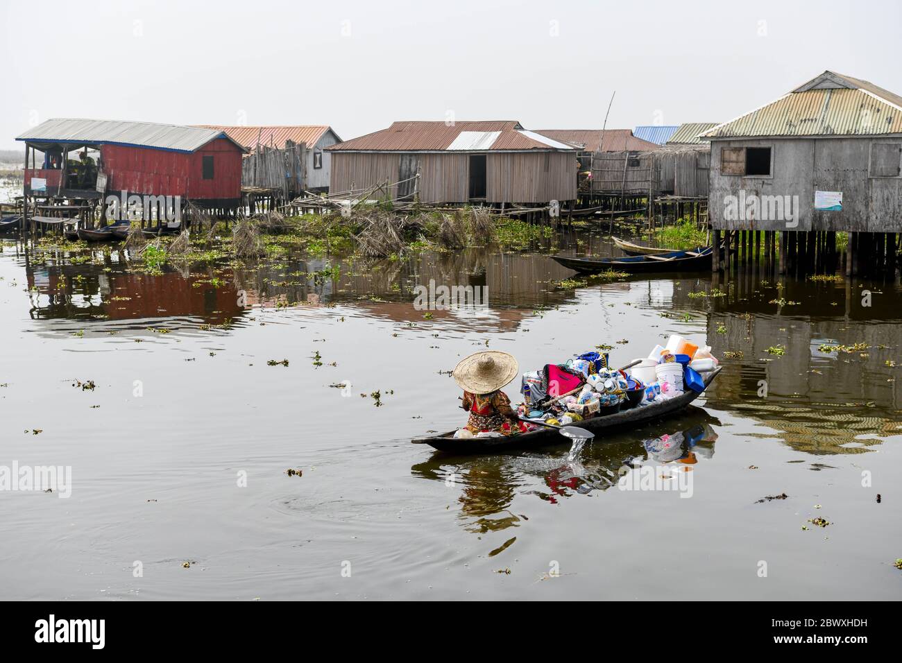 Afrique, Afrique de l'Ouest, Bénin, Lac Nokoue, Ganvié. Marchand voyageant sur pirogue dans la ville de Ganvié au bord du lac Nokoue. Banque D'Images