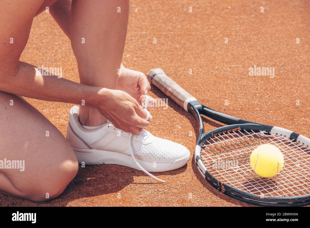 Femme professionnelle joueur de tennis nouant les lacets avant son match de tennis ou de compétition, sport concept, copyspace Banque D'Images