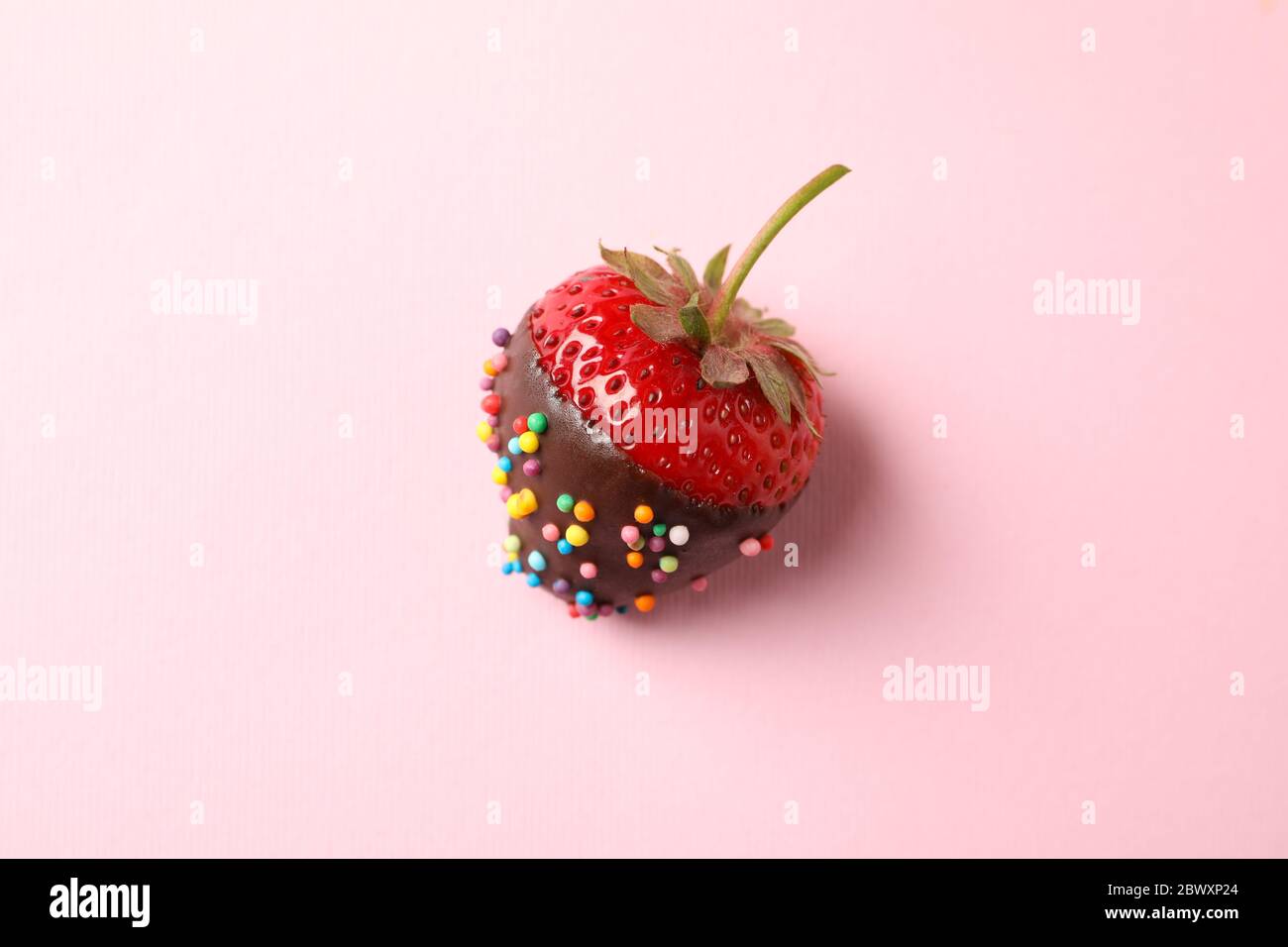 Fondue au chocolat. Fraise au chocolat sur fond rose Banque D'Images