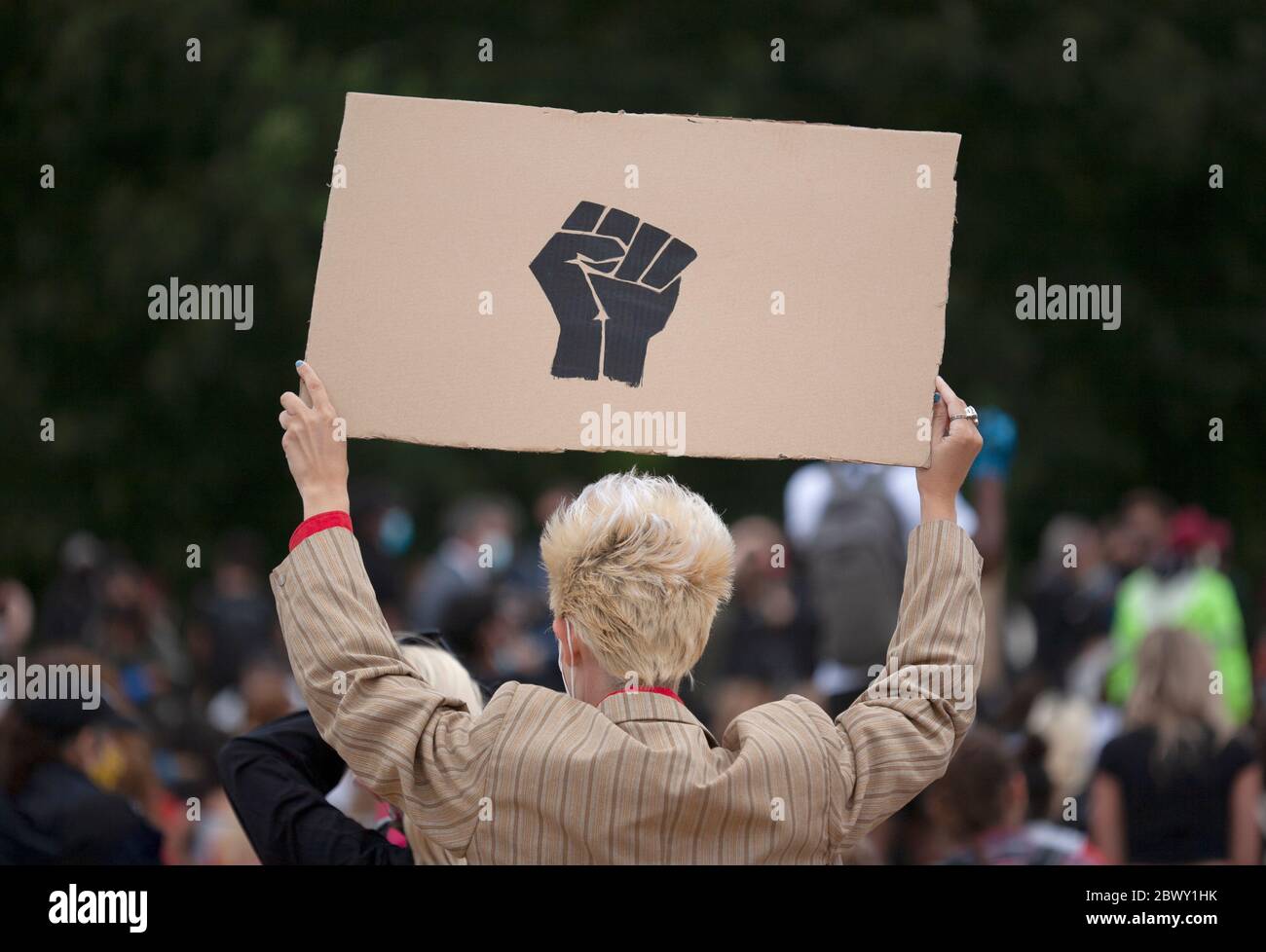 Homme blond aux cheveux tenant un panneau de poing noir fait maison, à la Black Lives Matter, marche de protestation britannique. Londres, Angleterre, Royaume-Uni Banque D'Images