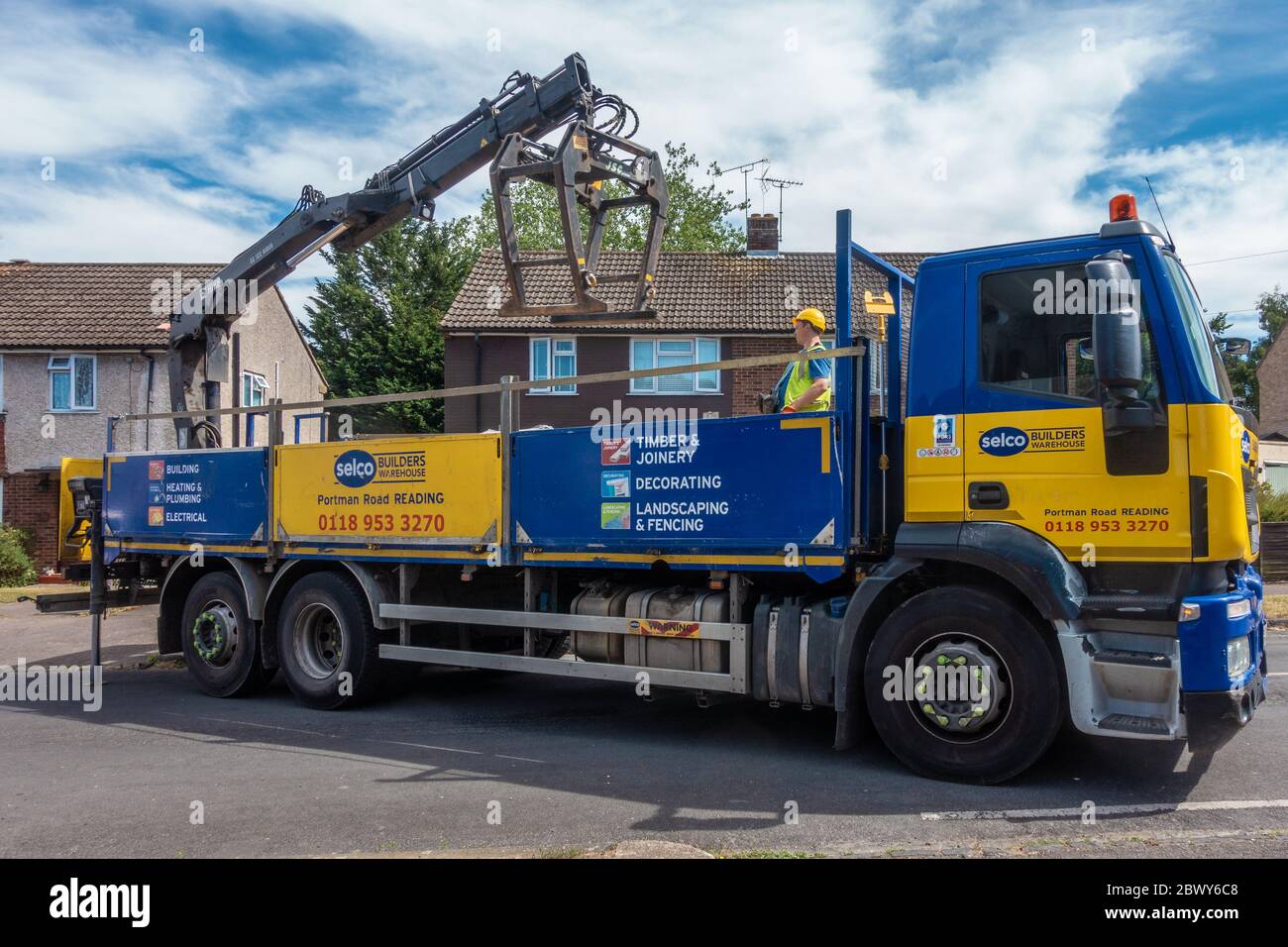 Un camion de livraison de marchands d’un constructeur Selco livre un sac de gravier à une maison. Banque D'Images