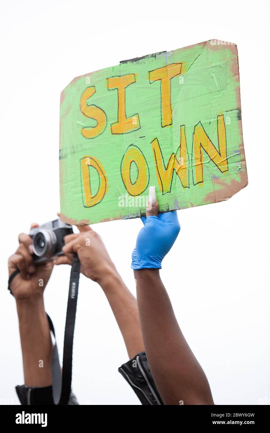 Une personne tenant un panneau « IT Down » et une autre tenant une caméra pendant la marche de protestation britannique Black Lives Matter. Londres, Angleterre, Royaume-Uni Banque D'Images