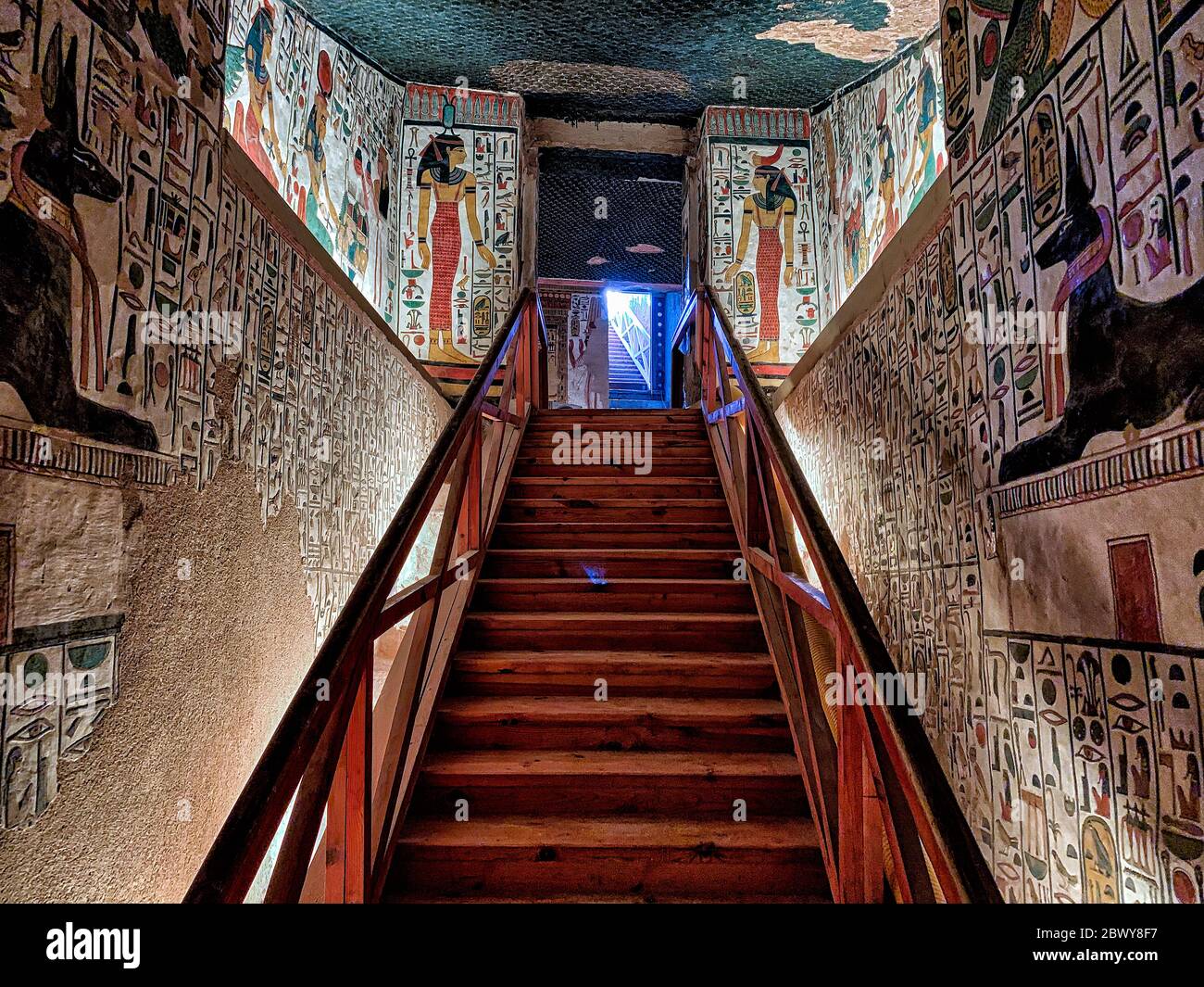 Les murs est et Ouest inférieurs montrent presque des images de miroir du jackal noir Anubis couché sur un sanctuaire de chaque côté de la rampe intérieure et de l'escalier Banque D'Images