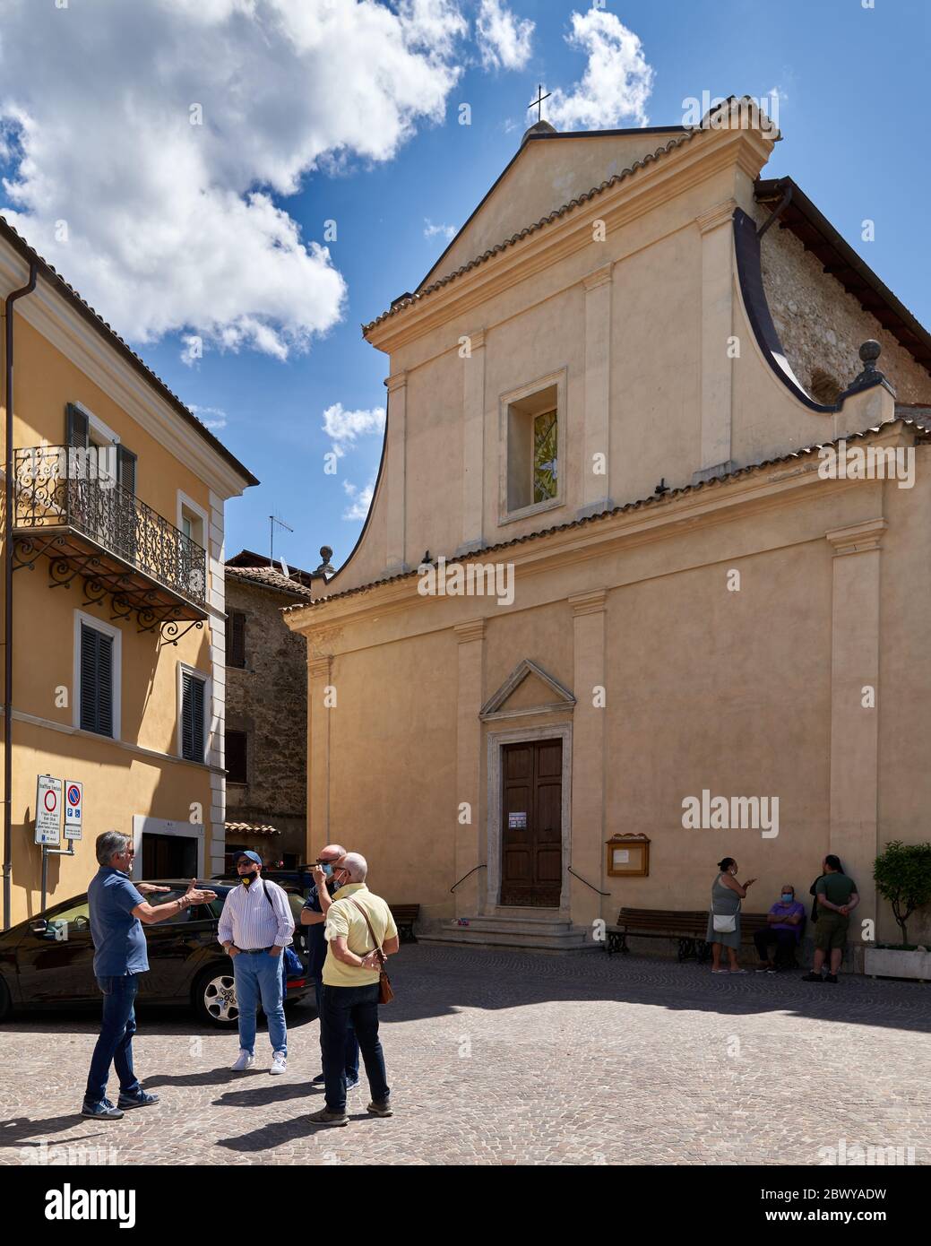 Trois hommes parlent en bon esprit dans une petite ville italienne typique de la place principale en face de l'église après trois mois dur de verrouillage du coronavirus Banque D'Images