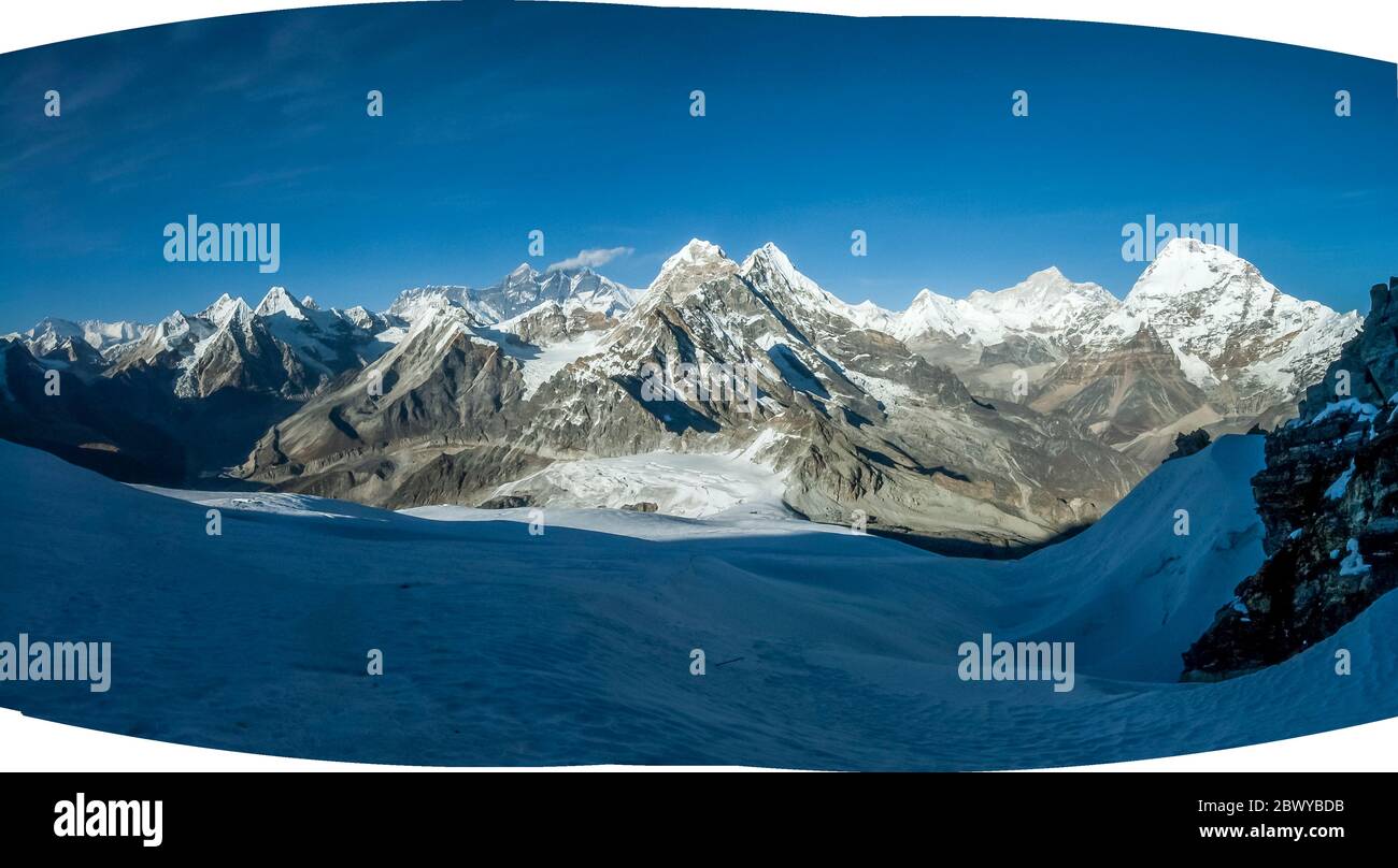 Népal. Partez à Mera Peak. Panorama panoramique des sommets de l'Himalaya depuis le sommet de Mera Peak à 6476m, en regardant dans la direction du mont Everest 8848m la plus haute montagne du monde sur l'horizon du centre lointain avec la queue de nuage, plus à droite est Makalu 8463m la montagne Rouge et le monde 5ème montagne la plus haute, À droite, en face de Makalu est Chamlang. La selle enneigée évidente en premier plan est le col de Mera la et le site de High Camp Banque D'Images