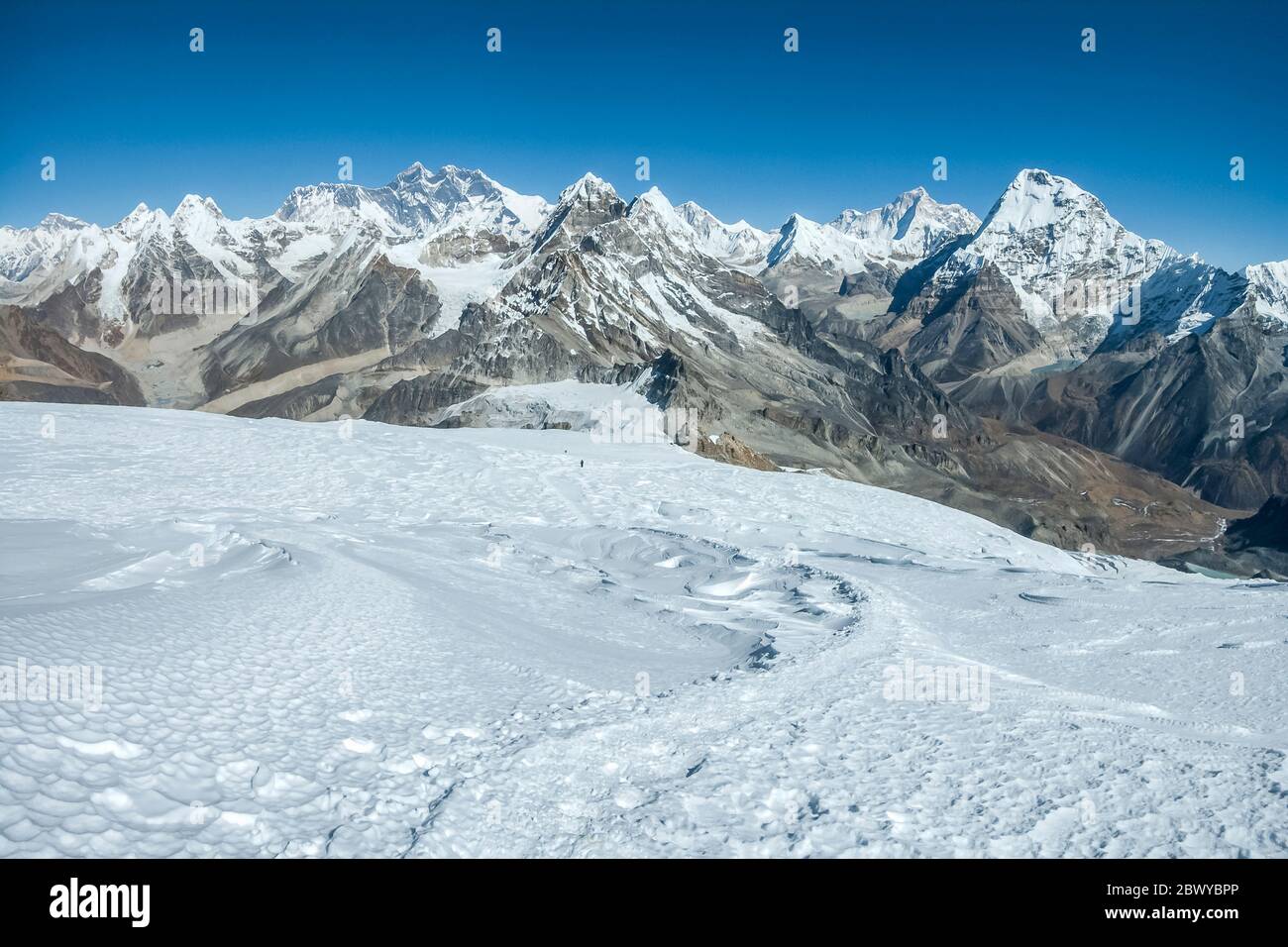 Népal. Partez à Mera Peak. Panorama panoramique des sommets de l'Himalaya depuis le sommet de Mera Peak à 6476m, regardant dans la direction du Mont Everest 8848m la plus haute montagne du monde dominant l'horizon du centre gauche, à droite du centre est Makalu 8463m la montagne Rouge et les mondes 5ème montagne la plus haute, Le sommet dominant à droite en face de Makalu est Chamlang, évident au premier plan est la selle enneigée de Mera la Pass Banque D'Images