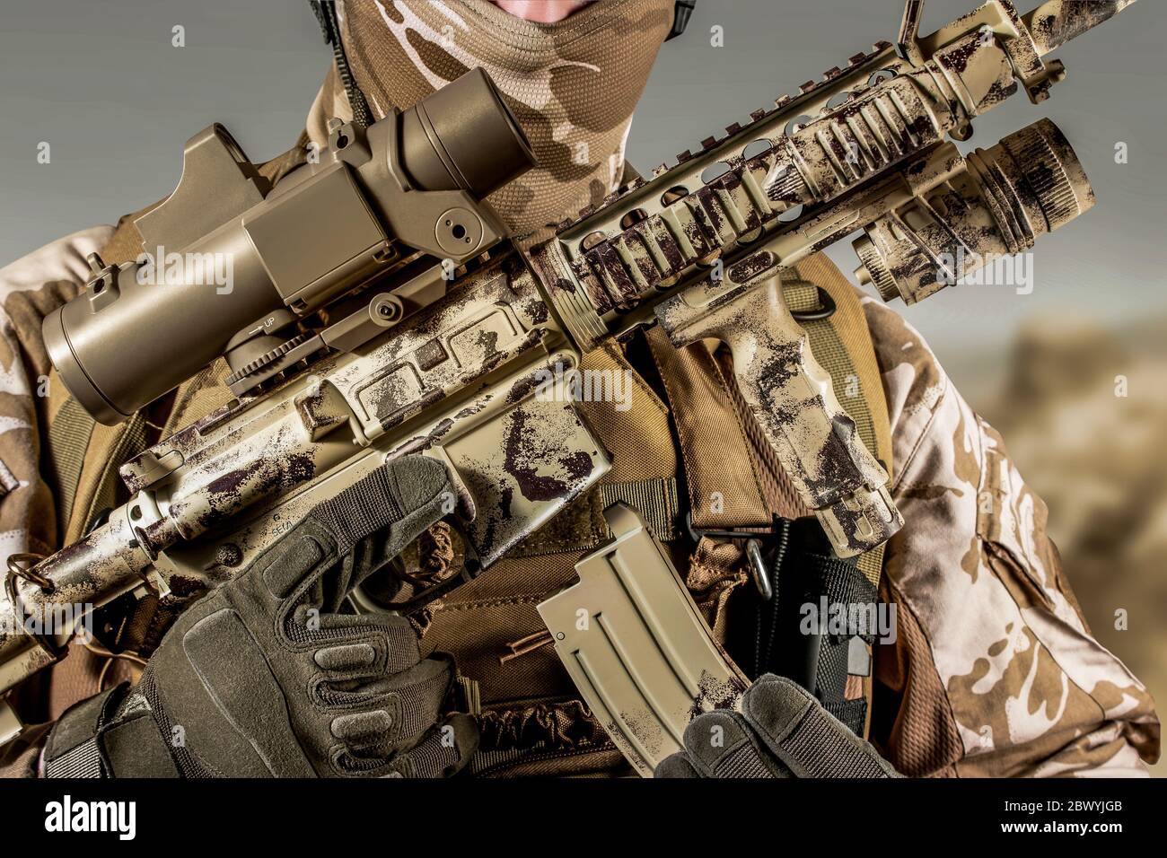 Photo d'un soldat du désert entièrement équipé tenant une carabine automatique avec clip. Banque D'Images