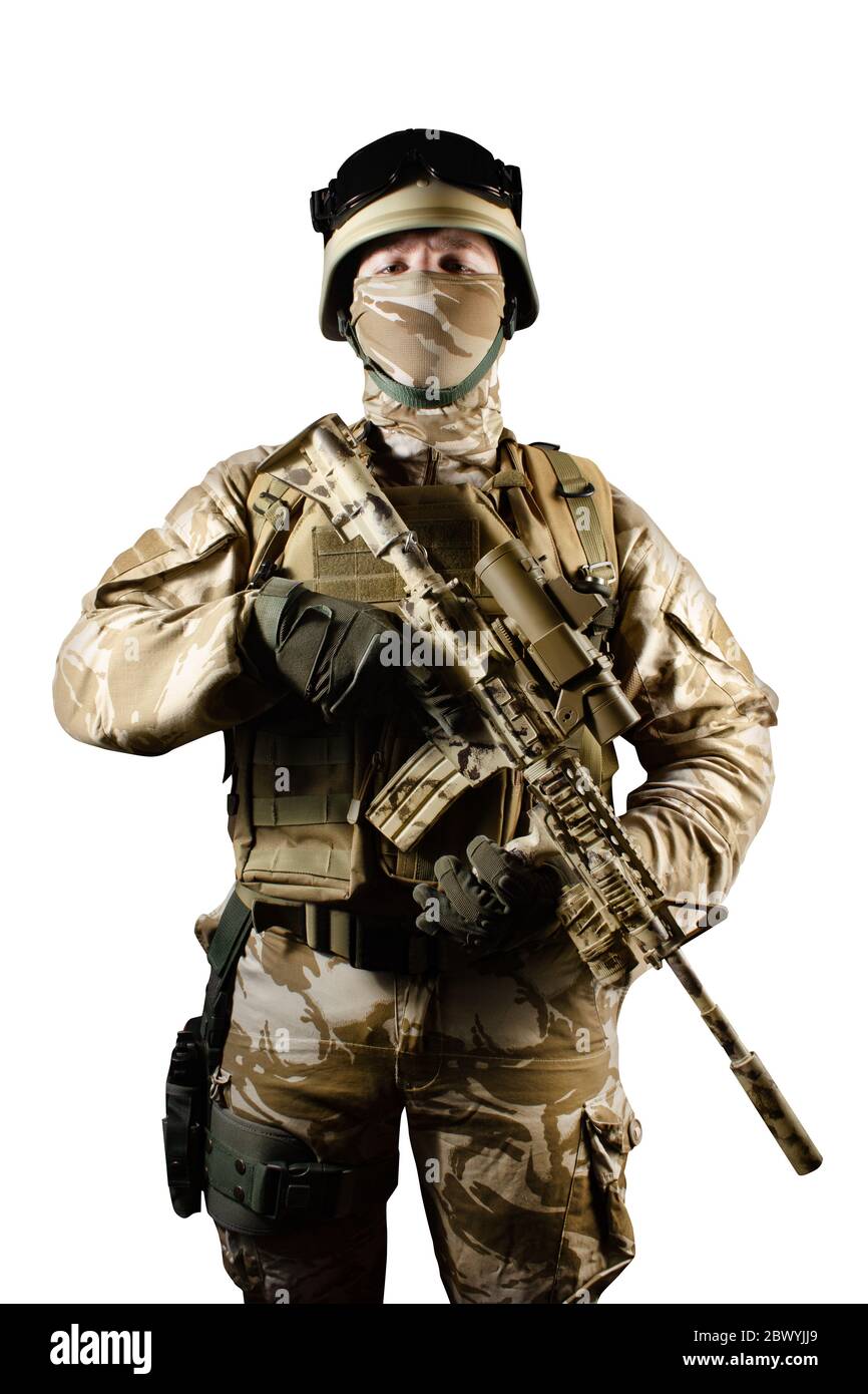Photo isolée d'un soldat entièrement équipé debout et posant armé d'un fusil automatique sur fond blanc. Banque D'Images