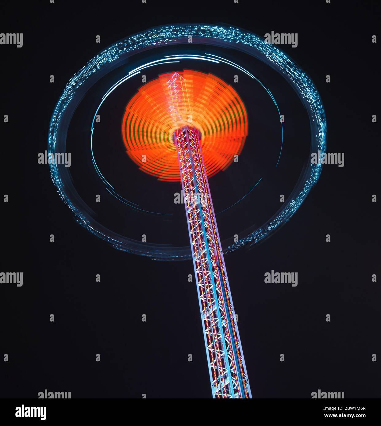 Parcours de foire tournoyant illuminé la nuit avec des lumières vives Banque D'Images