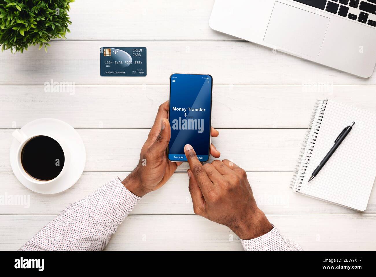 E-banking. Homme noir méconnu utilisant l'application de transfert d'argent sur smartphone, vue de dessus Banque D'Images