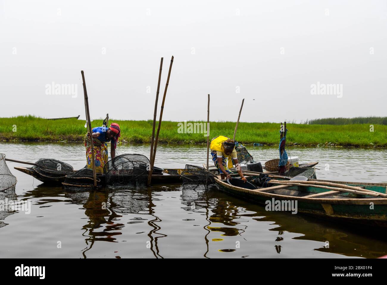 Afrique, Afrique de l'Ouest, Bénin, Lac Nokoue, Ganvié. Les pêcheurs se chargent de leurs filets sur le lac Nokoue, à l'extérieur de la ville de Ganvié, au bord du lac. Banque D'Images