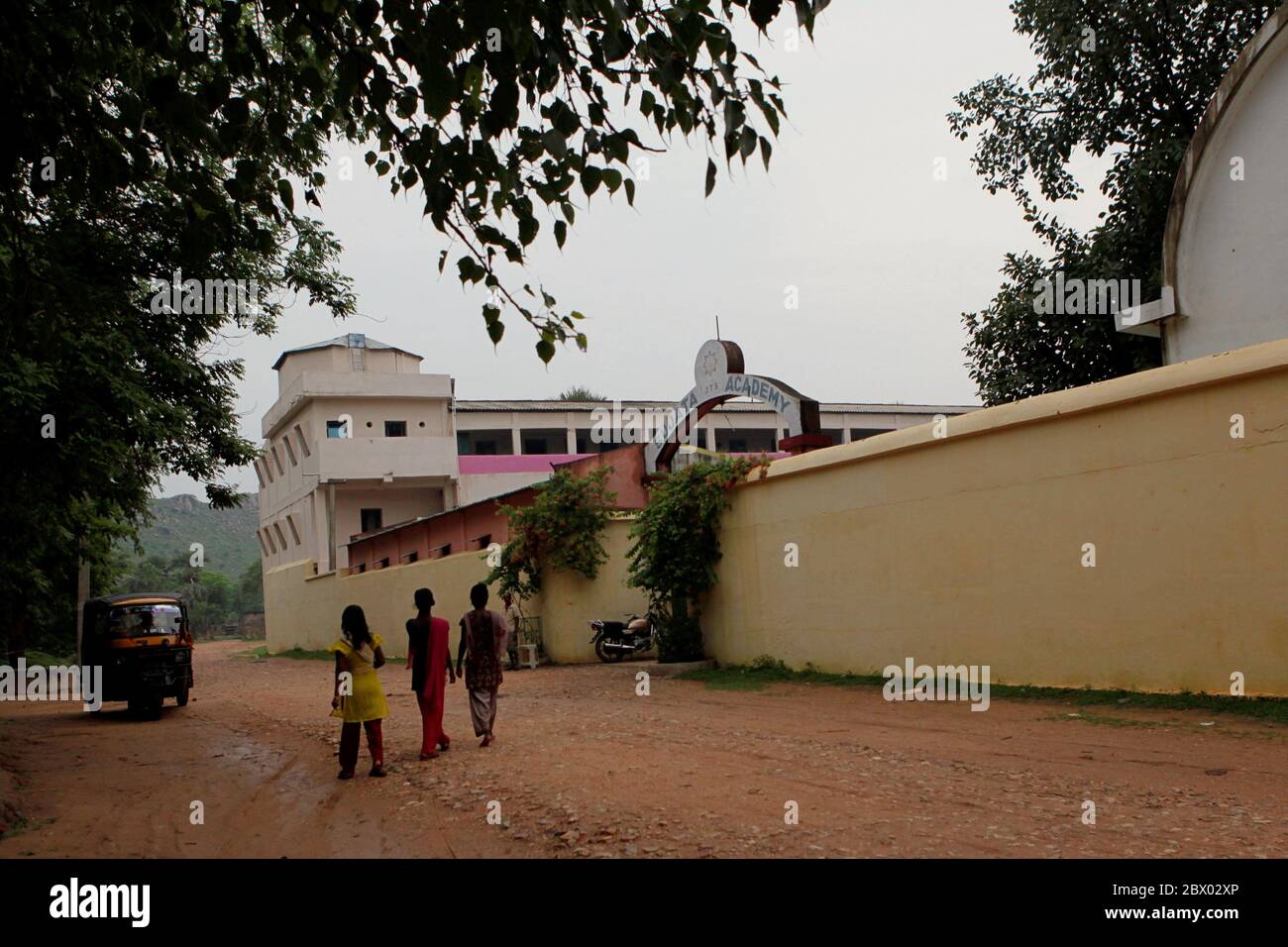 Des adolescents se réveillant sur la route rurale en face du complexe de l'Académie de Sujata dans le village de Dungeshwari à Bihar, en Inde. Construit comme aide à l'éducation des enfants en milieu rural, le complexe scolaire et dortoir gratuit est géré par Join Together Society, une organisation de secours basée en Corée du Sud. Selon les statistiques de l'UNESCO, le nombre d'enfants non scolarisés en Inde s'élevait en 2013 à plus de 2 millions (hommes) et près de 1 millions (femmes). Le Bihar est l'un des États les plus pauvres de l'Inde. Banque D'Images