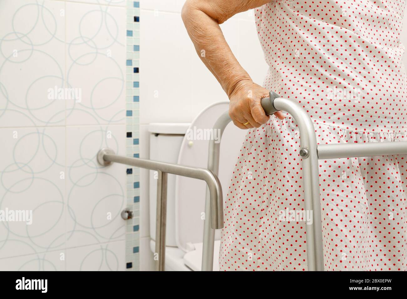 Femme âgée tenant une marchette dans les toilettes. Banque D'Images