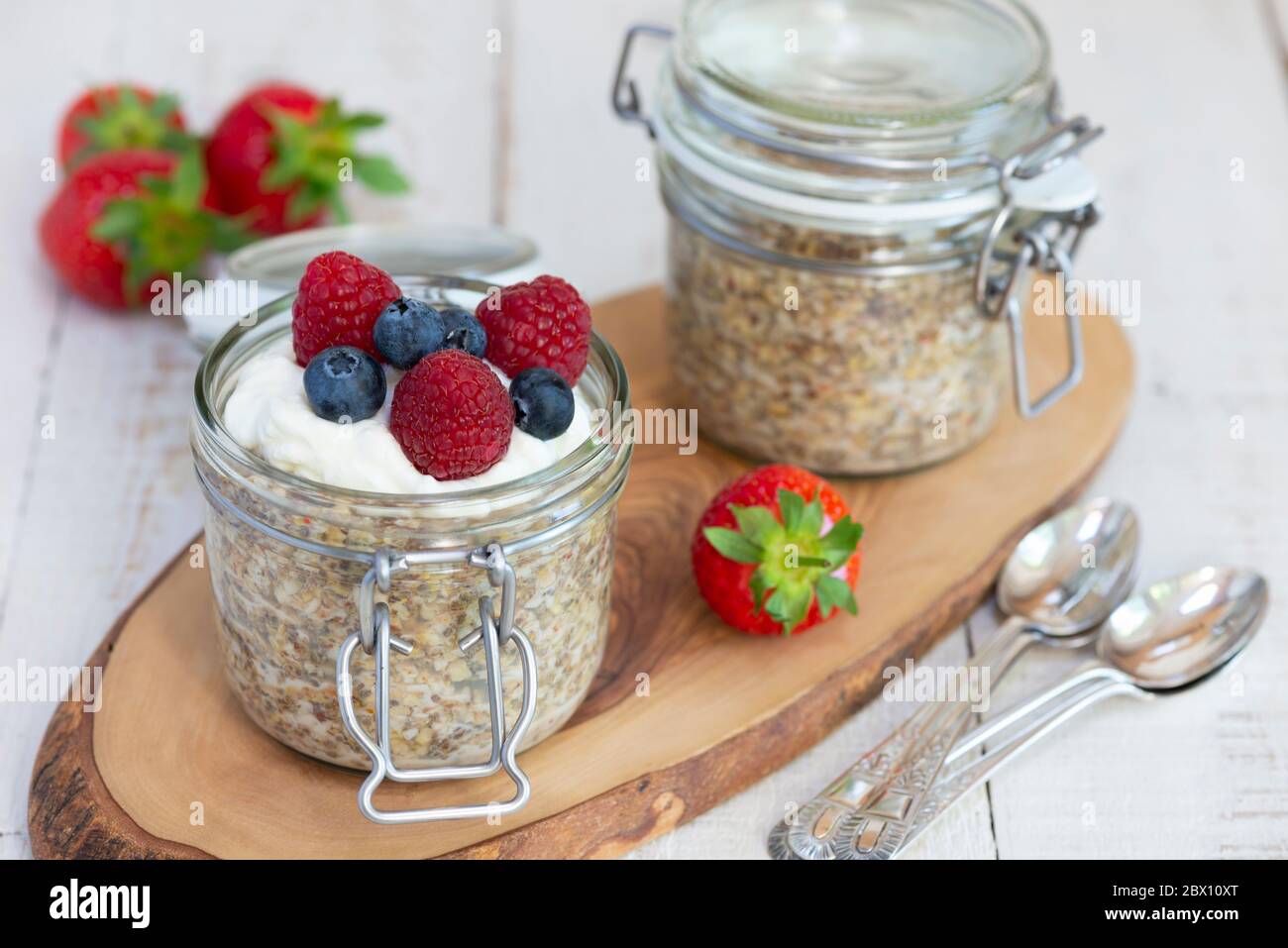 Pots de petit déjeuner à l'avoine servis avec yaourt grec, myrtilles et framboises. Banque D'Images