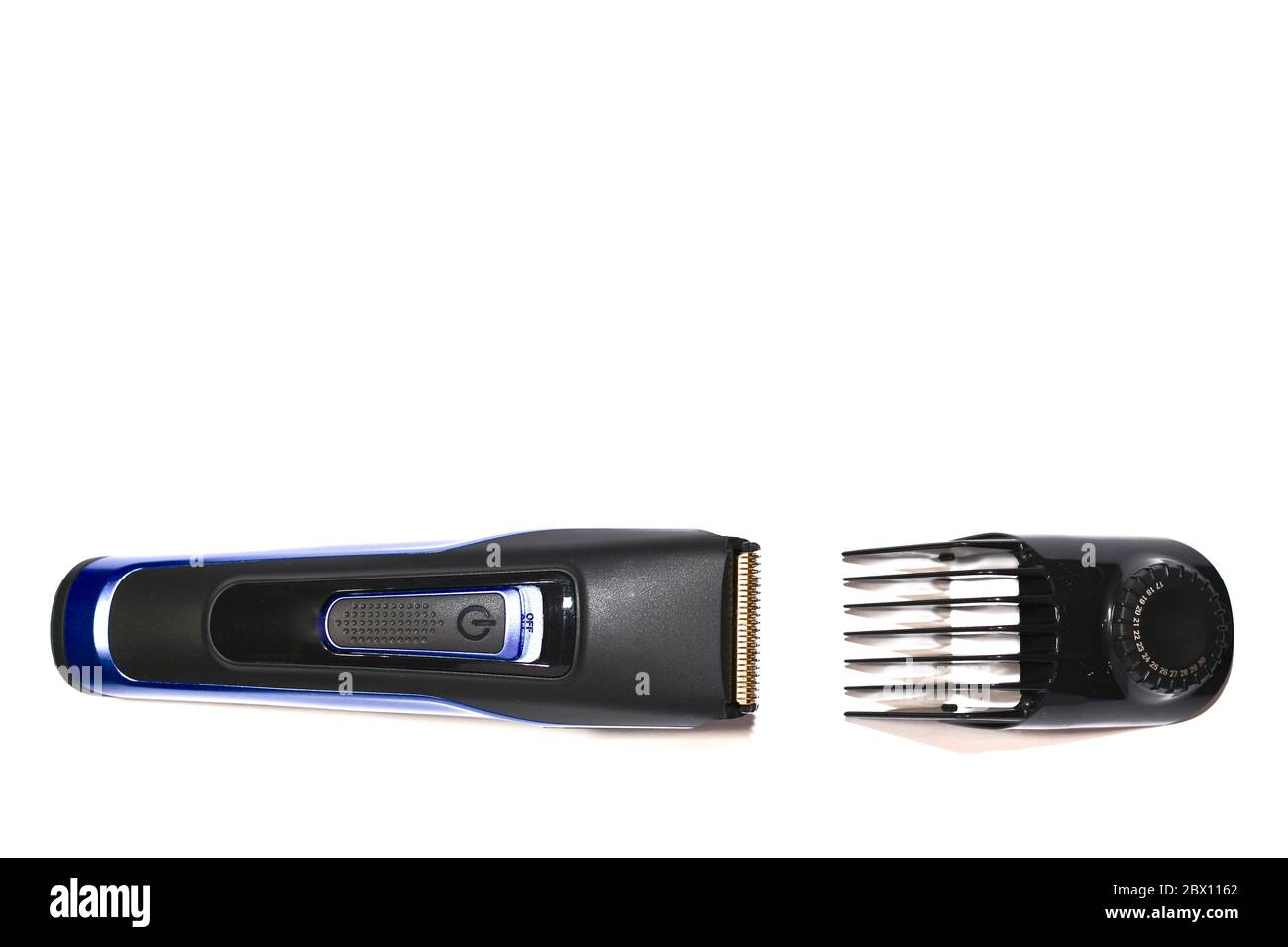 Une machine à couper les cheveux et une brosse sur fond blanc. Banque D'Images