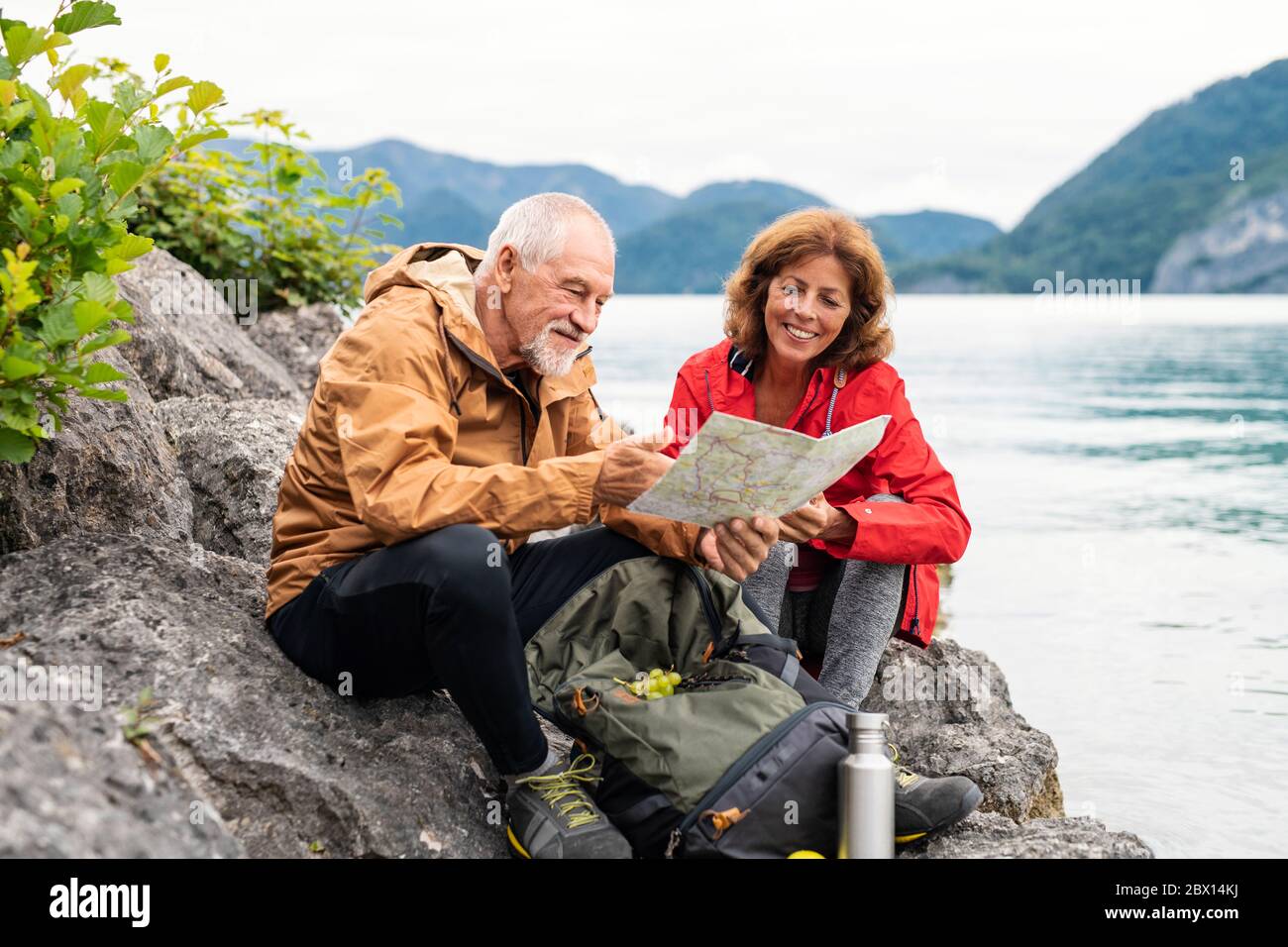 Un couple de retraités seniors randonnée par lac dans la nature, en utilisant la carte. Banque D'Images