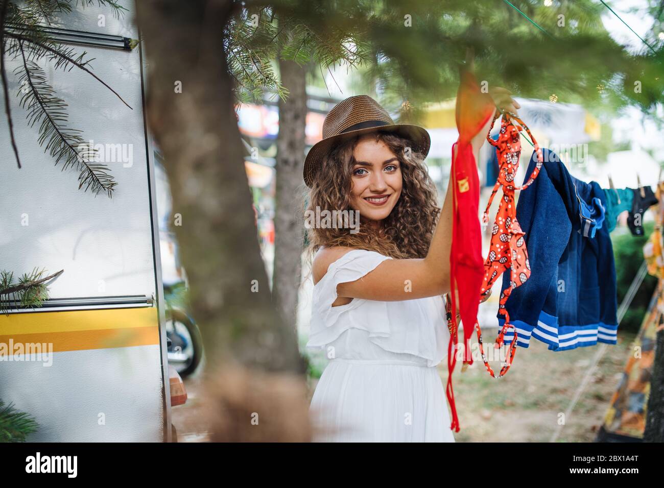 Une jeune femme qui pendait des serviettes à un festival d'été ou à des vacances de camping. Banque D'Images