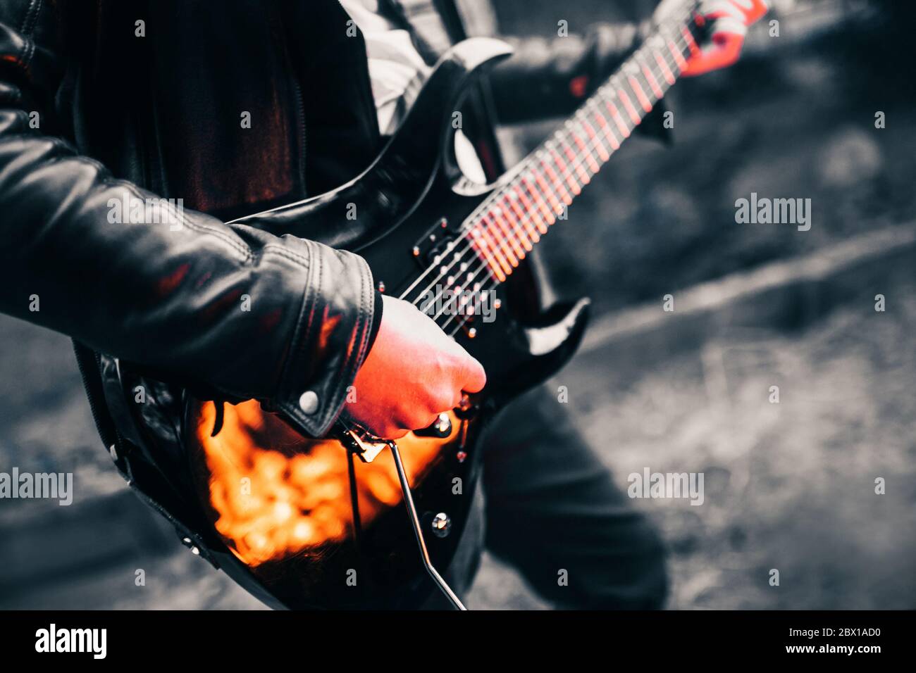 Guitariste jouant du hard rock sur une guitare électrique noire dans le  noir - reflet du feu Photo Stock - Alamy